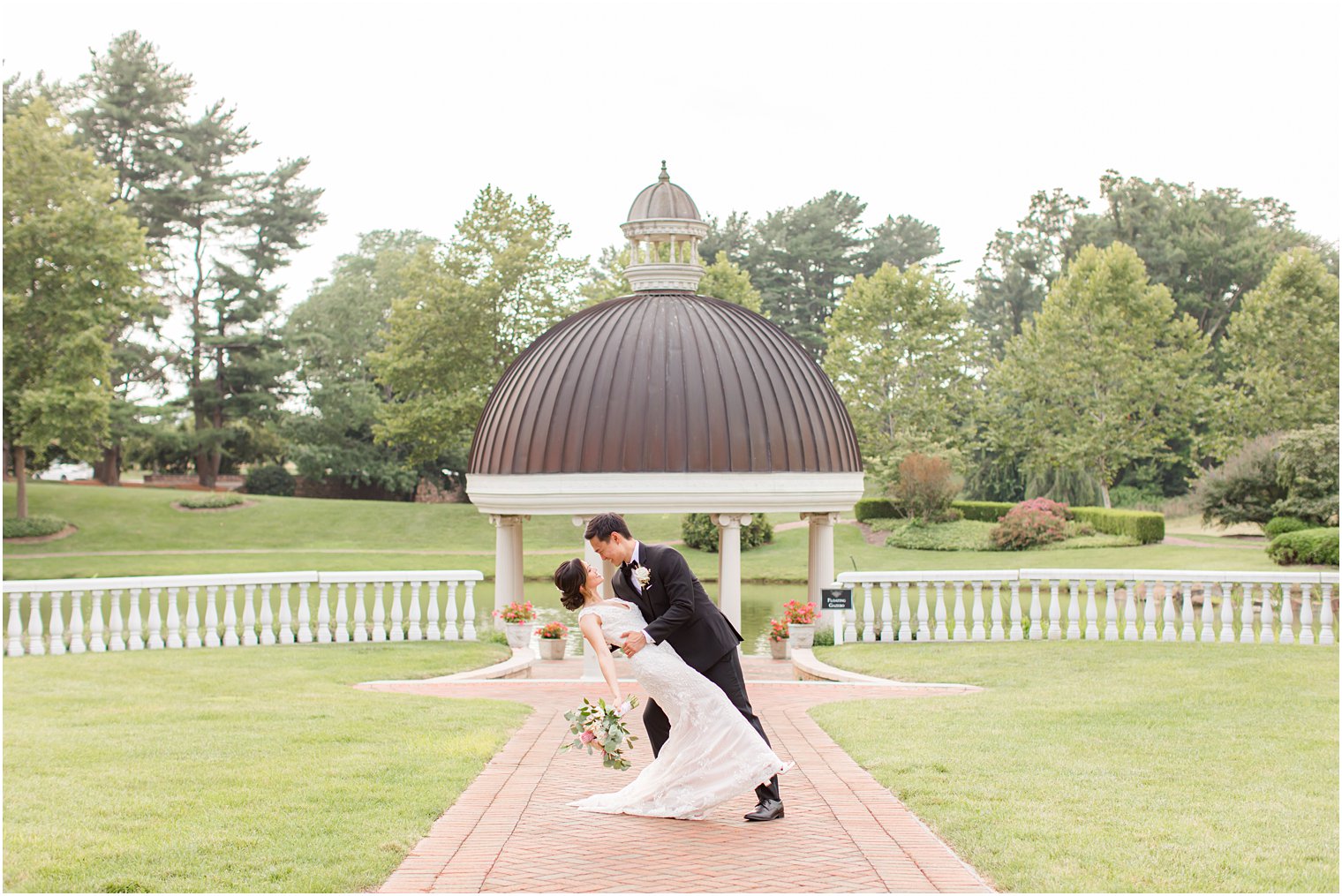 groom dips bride outside gazebo at Ashford Estate