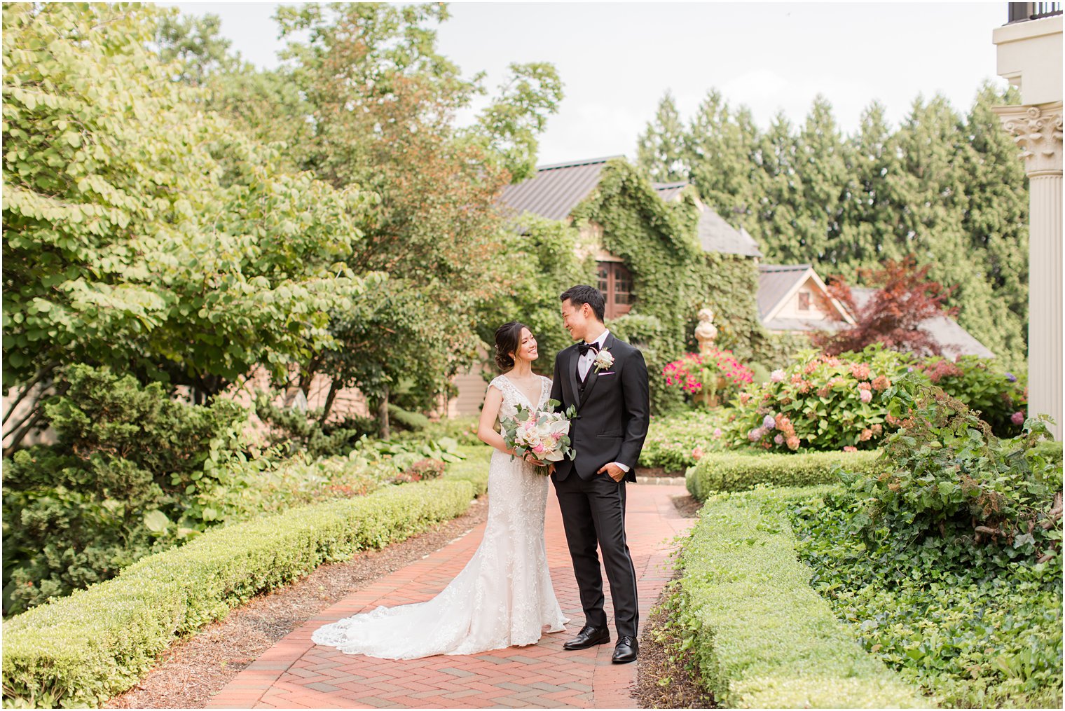 bride and groom stand together on pathway in gardens of Ashford Estate