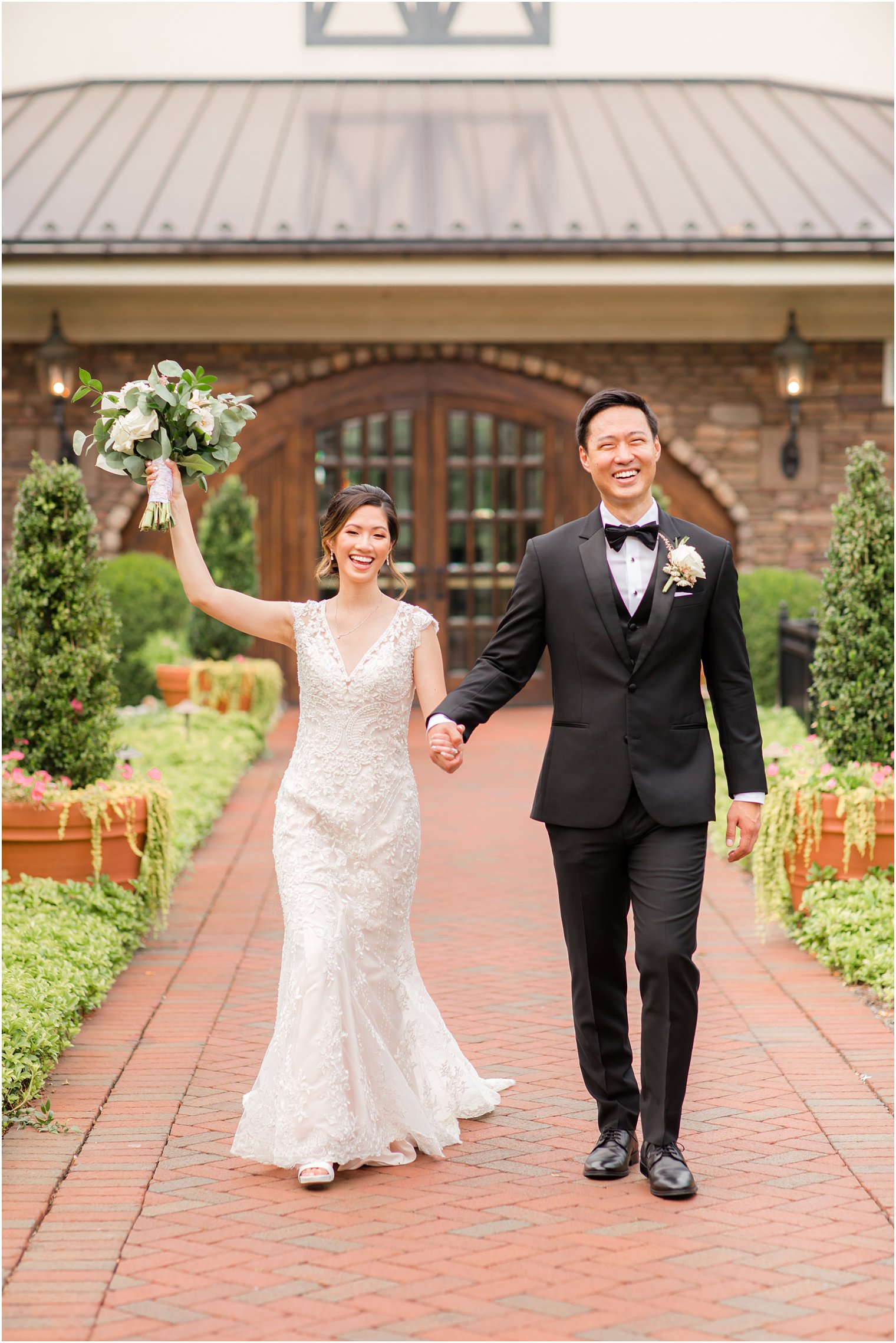 bride and groom cheer holding hands walking outside Ashford Estate 