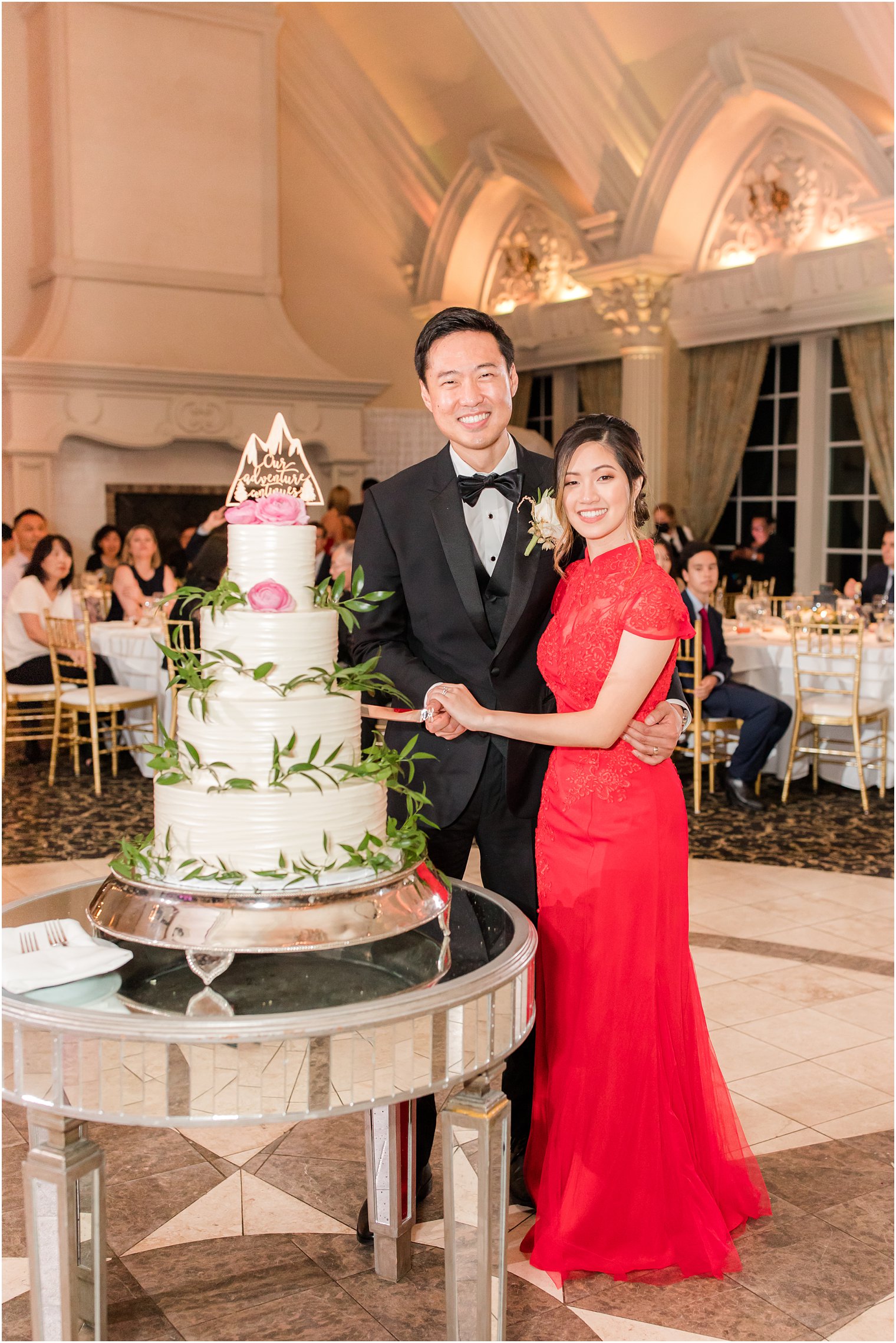 newlyweds pose by tiered wedding cake during Ashford Estate wedding reception