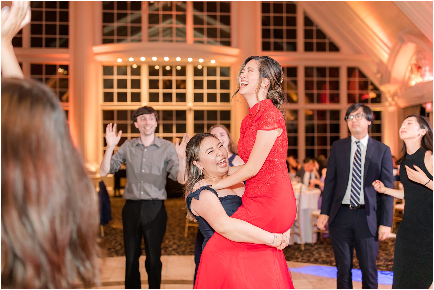 bridesmaid lifts up bride during NJ wedding reception 