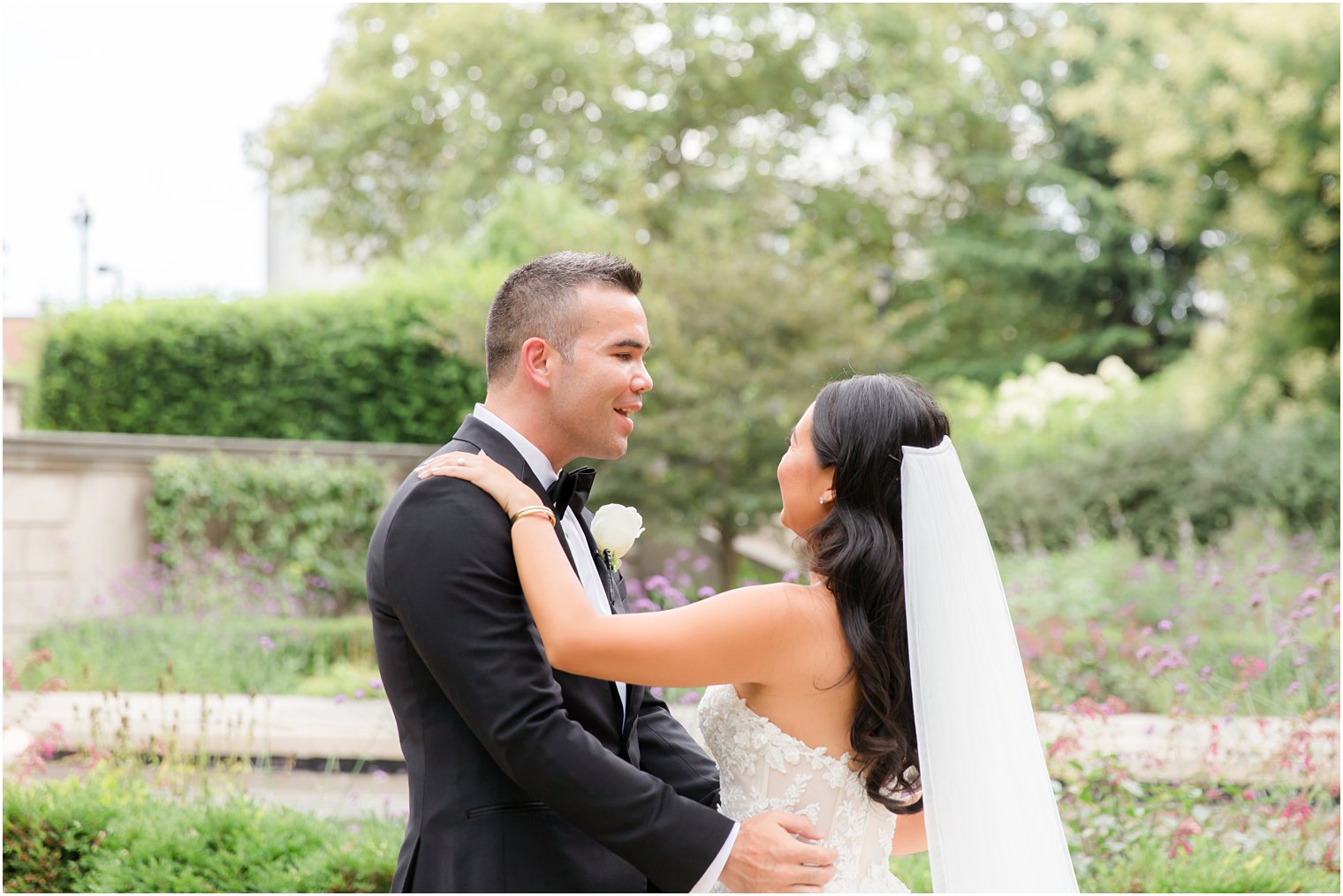 bride and groom hug in gardens of Rodin Museum