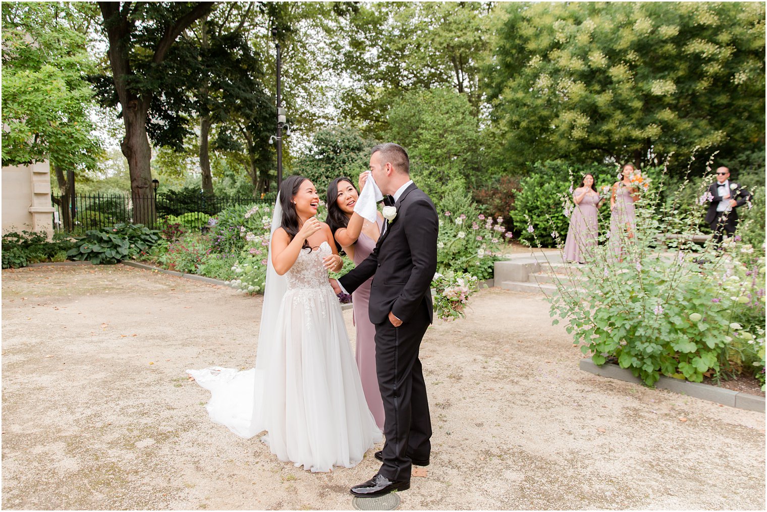 bridesmaid wipes groom's tear with handkerchief during first look