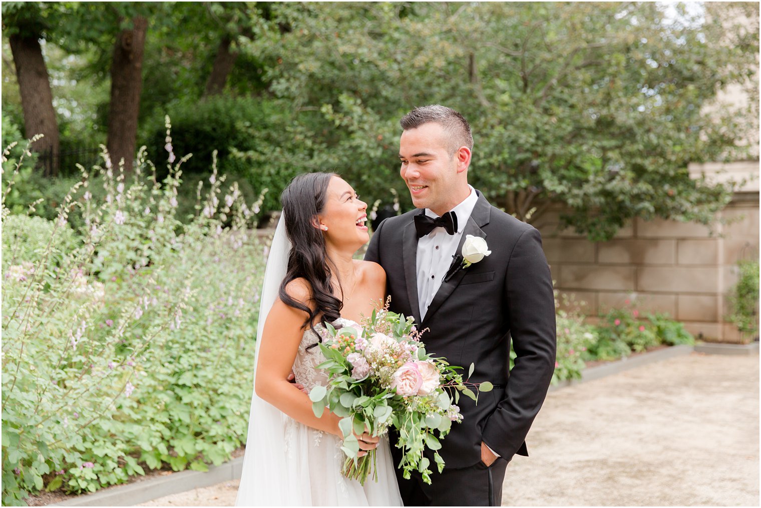 bride and groom laugh together in gardens of Philly museum 