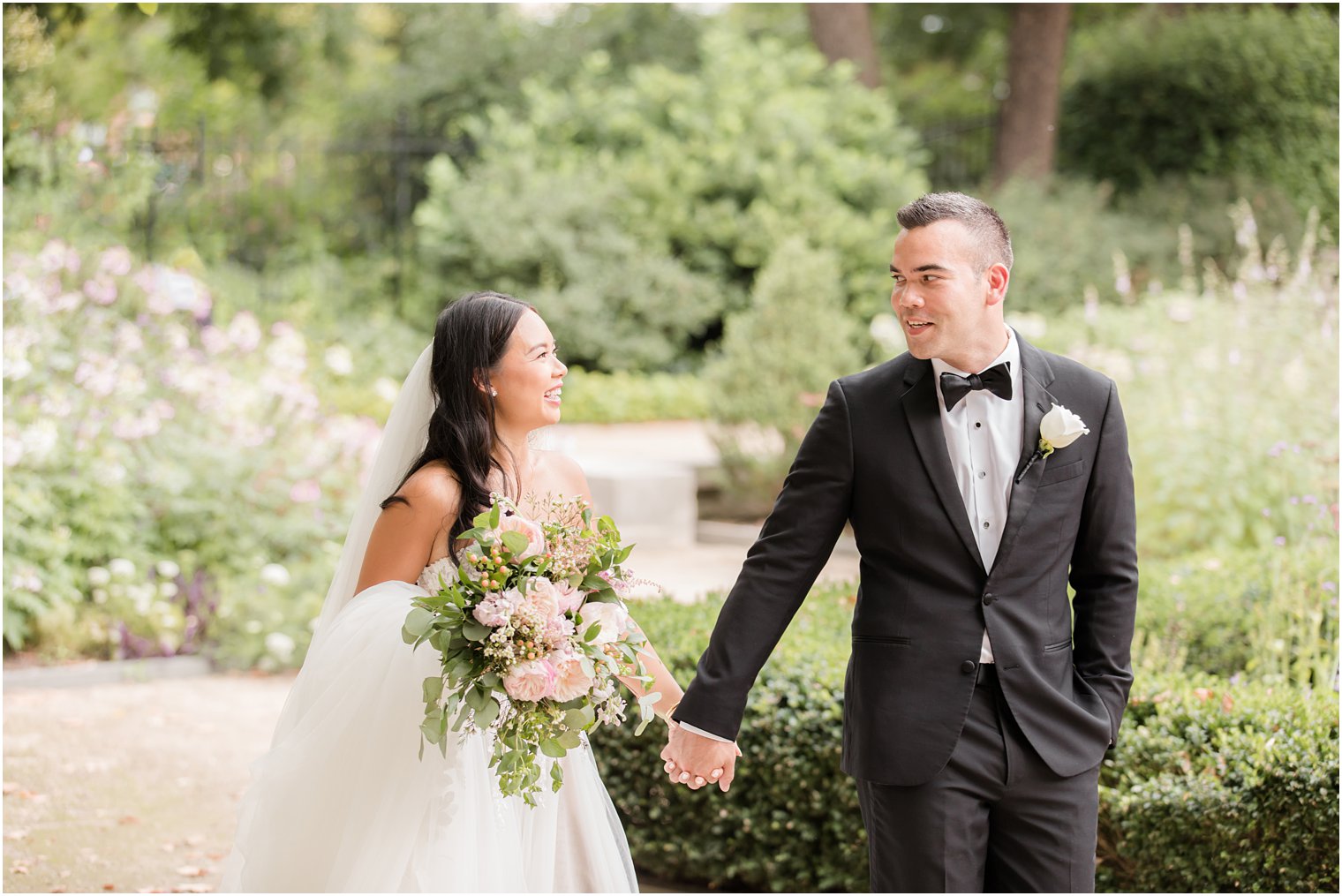groom leads bride through gardens at Rodin Museum