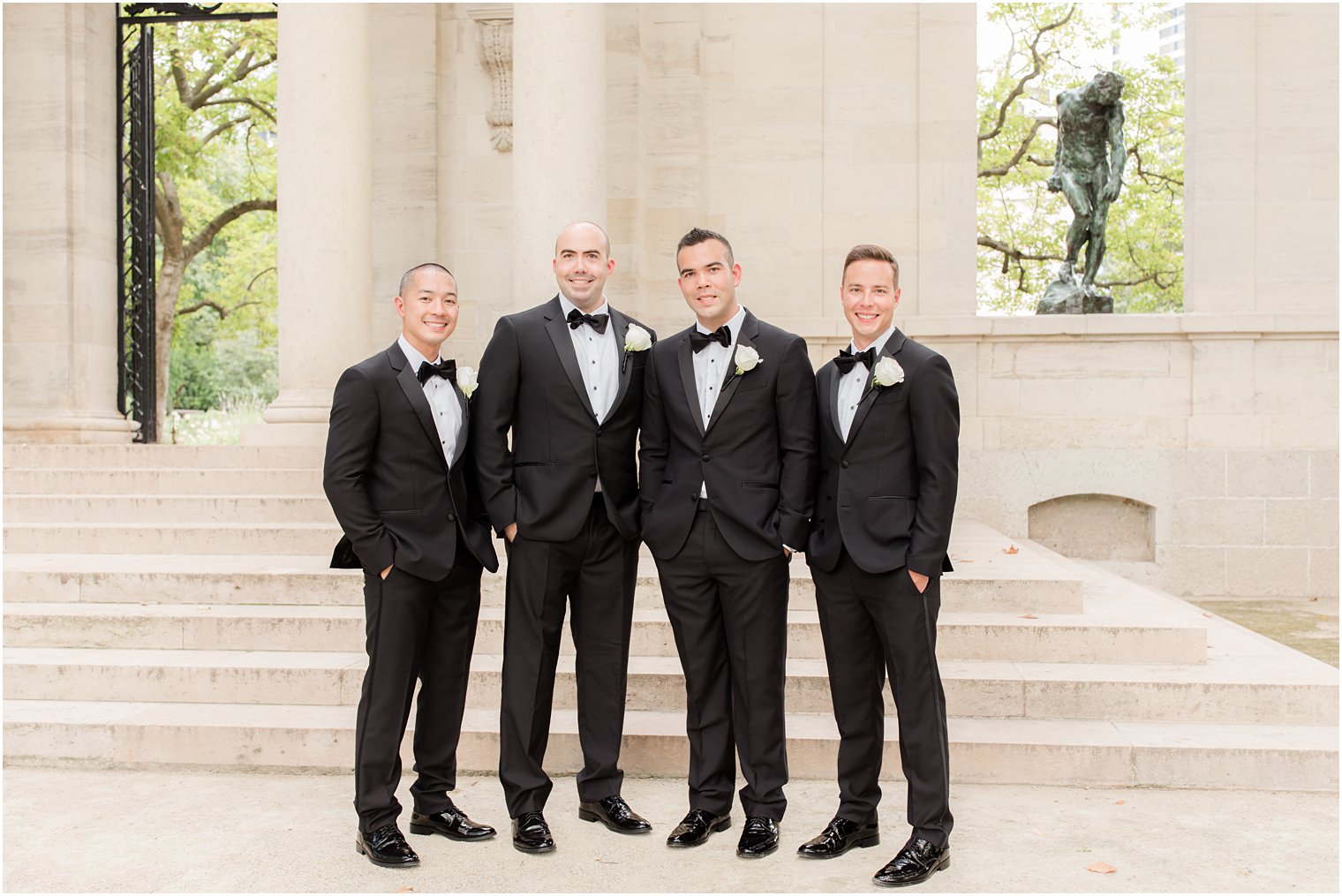 groom and groomsmen pose in classic black tuxes