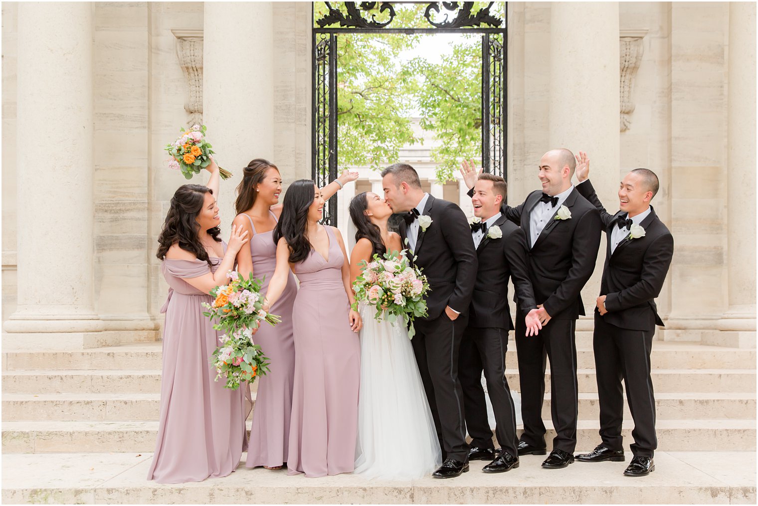 bride and groom kiss in Philly PA with wedding party