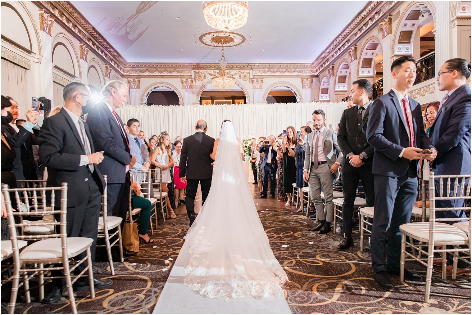 bride walks down aisle with dad at Ballroom at the Ben wedding