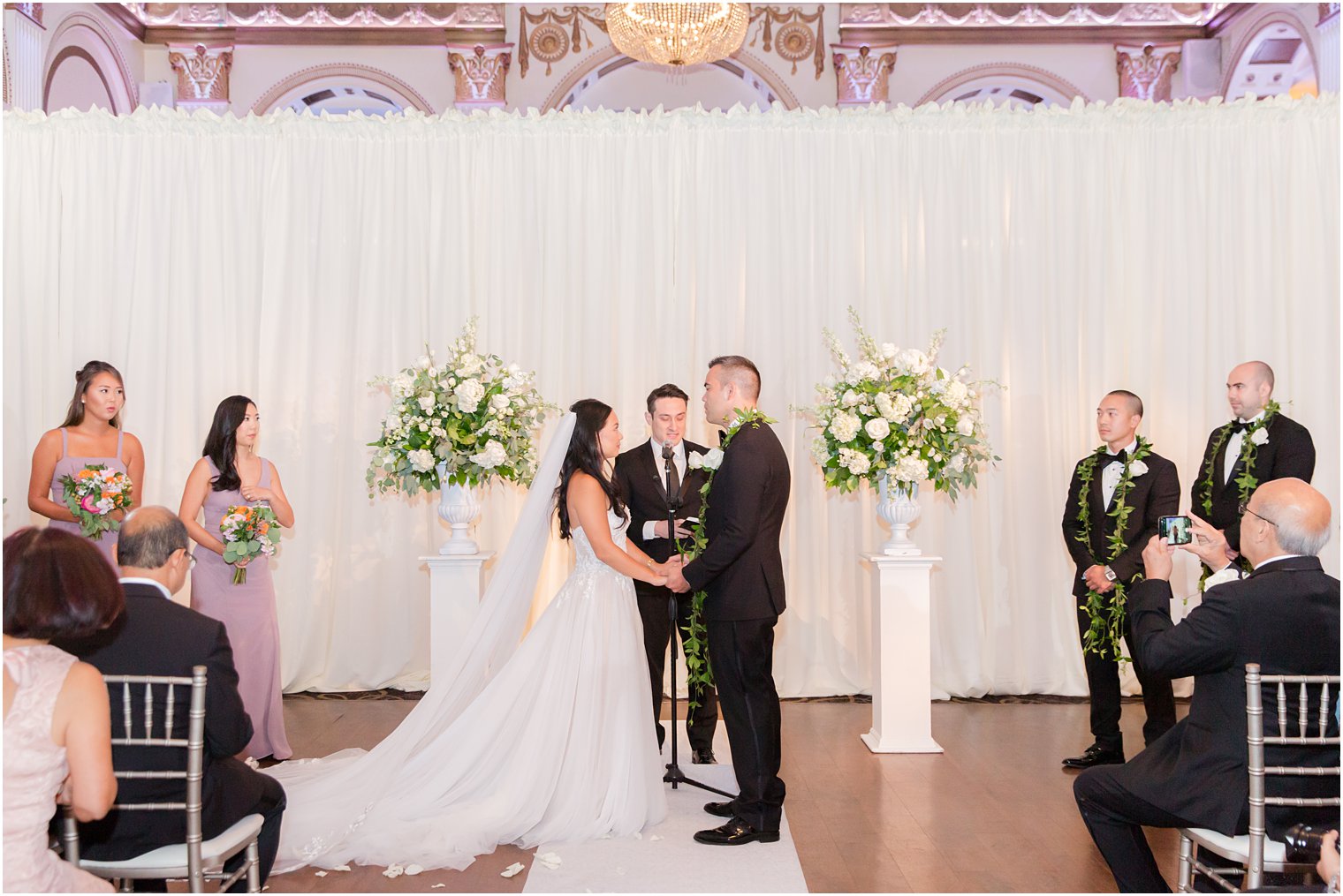 newlyweds hold hands during Ballroom at the Ben wedding ceremony