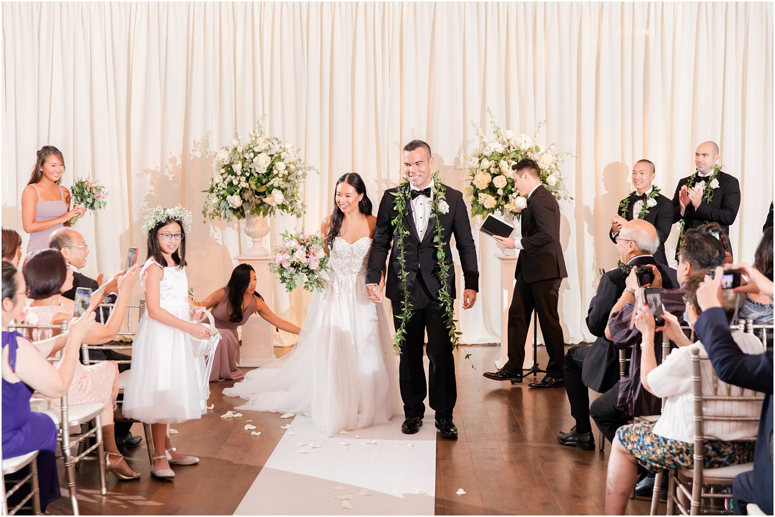 newlyweds hold hands leaving wedding ceremony in Philly