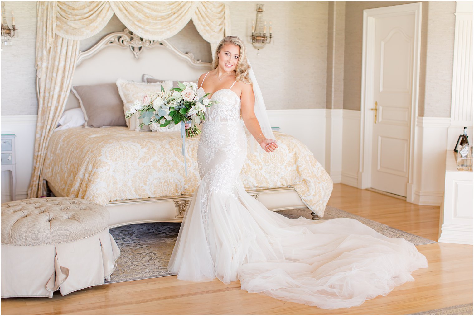 bride holds bouquet in bridal suite with train behind her