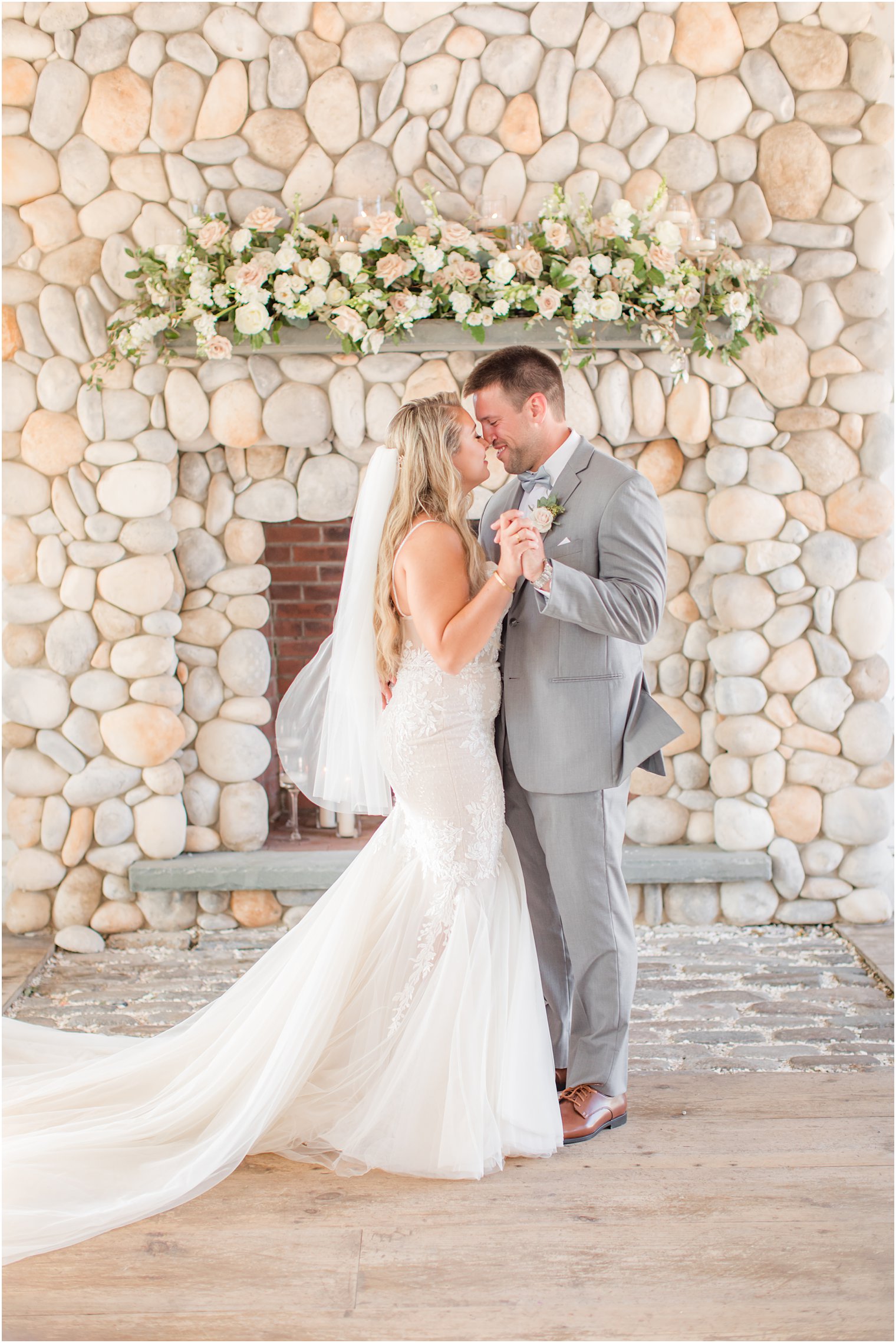 bride and groom dance in front of stone fireplace at Bonnet Island Estate