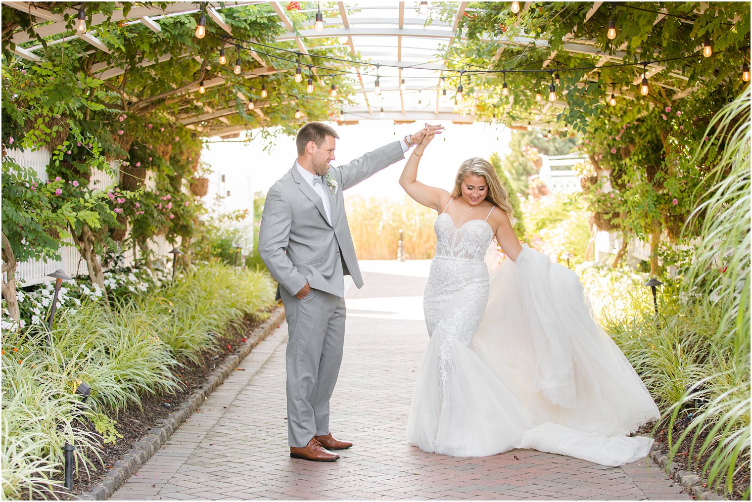 groom twirls bride in rose garden at Bonnet Island Estate