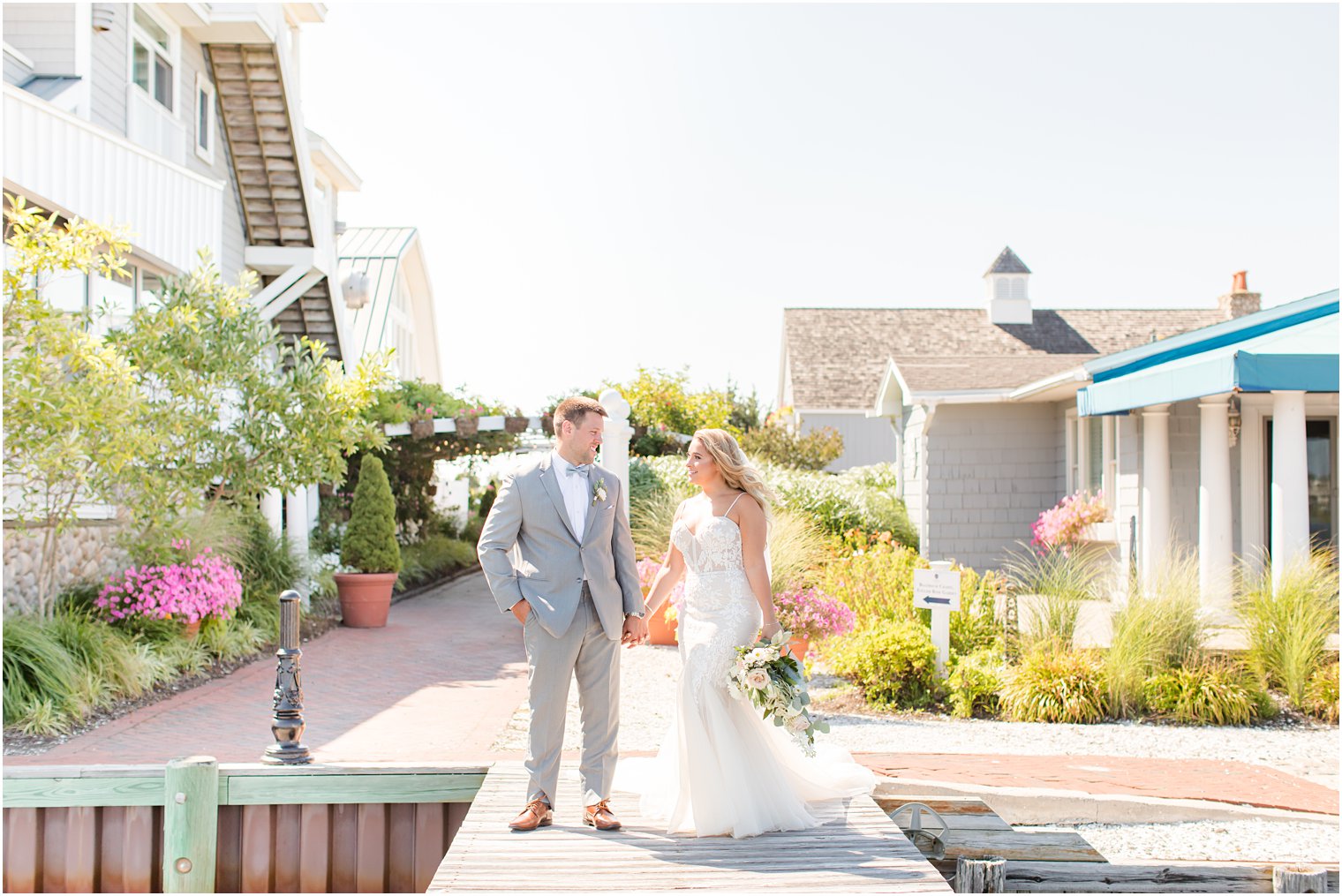 newlyweds hold hands walking through Bonnet Island Estate
