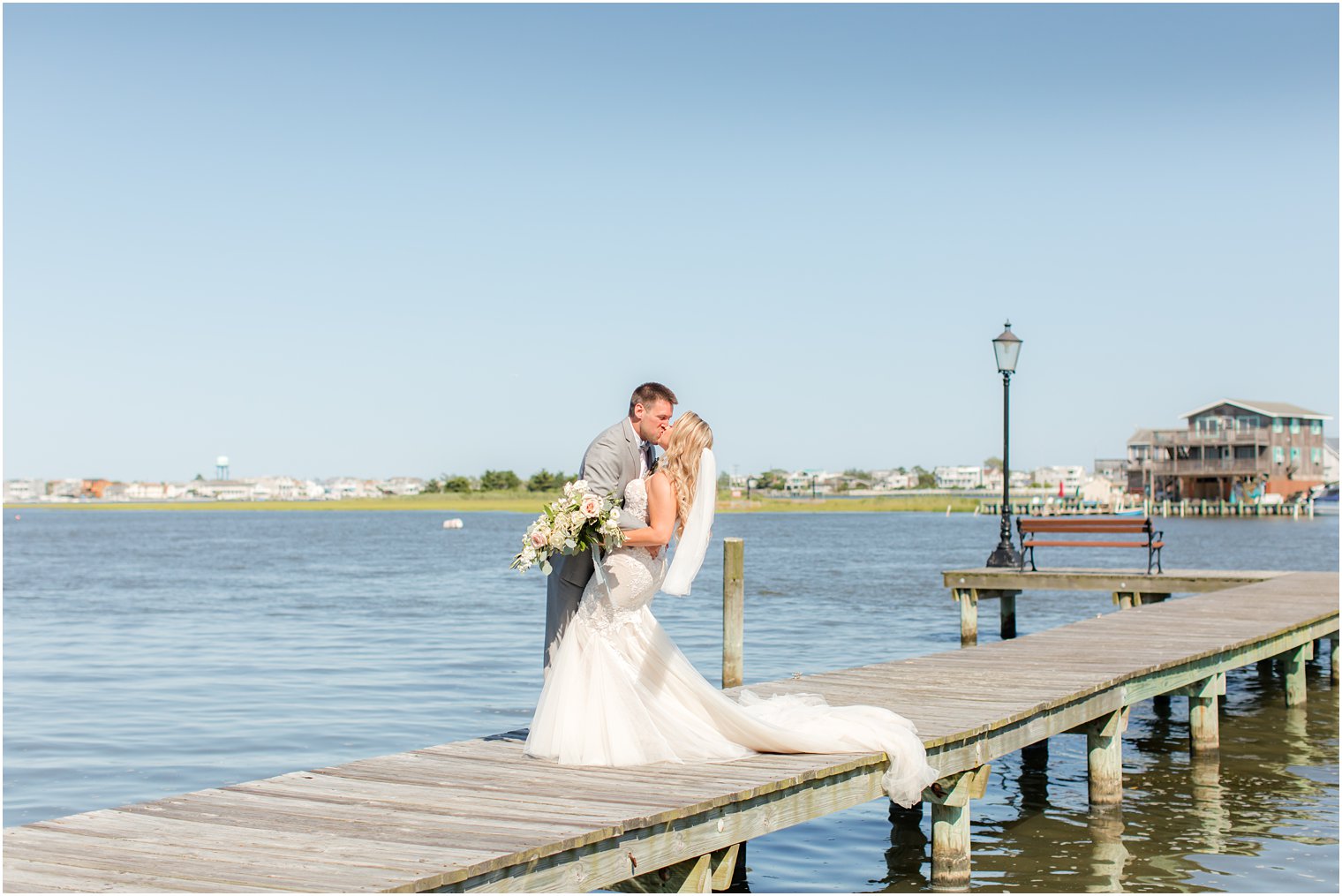 newlyweds kiss on dock at Bonnet Island Estate