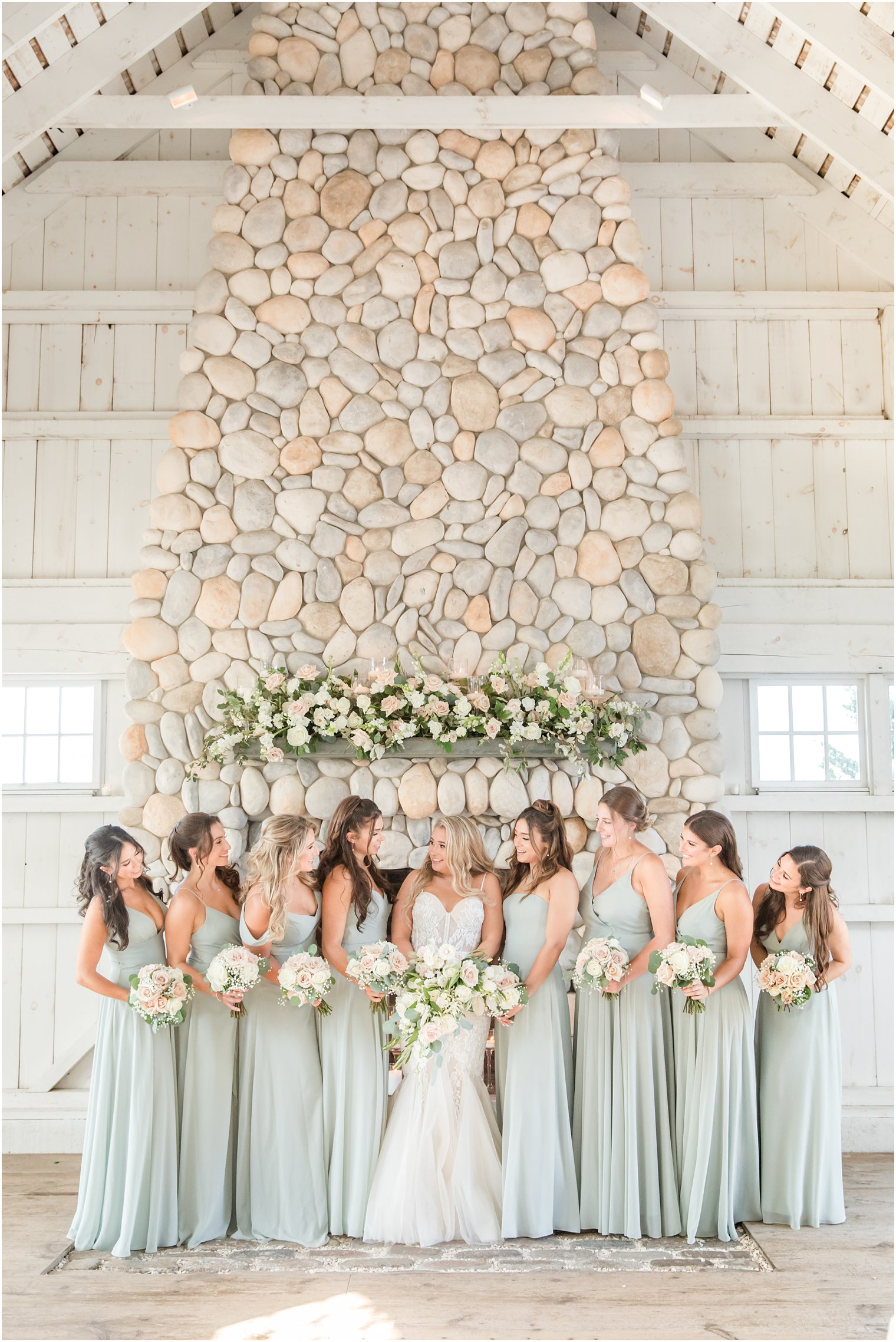 bride poses with bridesmaids in light mint gowns