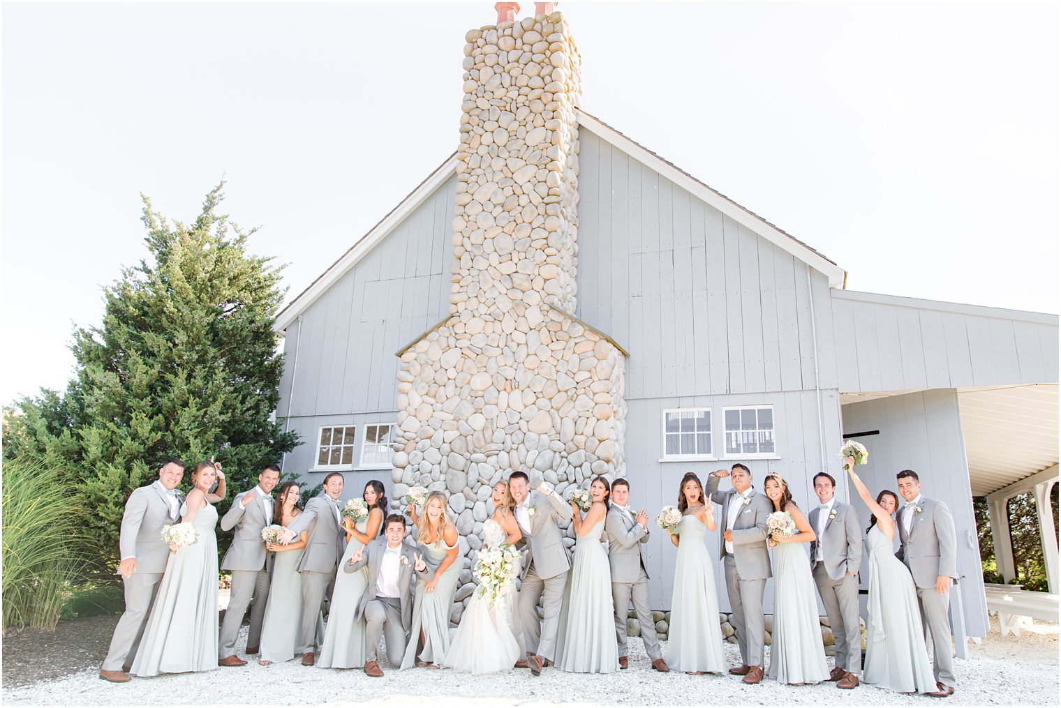 newlyweds cheer with wedding party outside Bonnet Island Estate barn