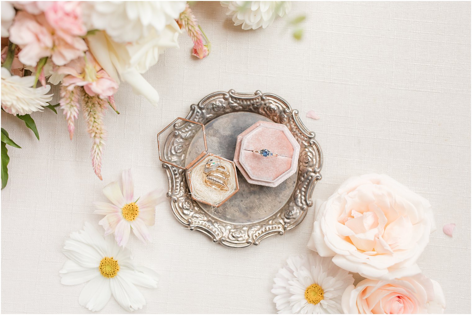 wedding bands in pink and rose gold boxes on silver tray