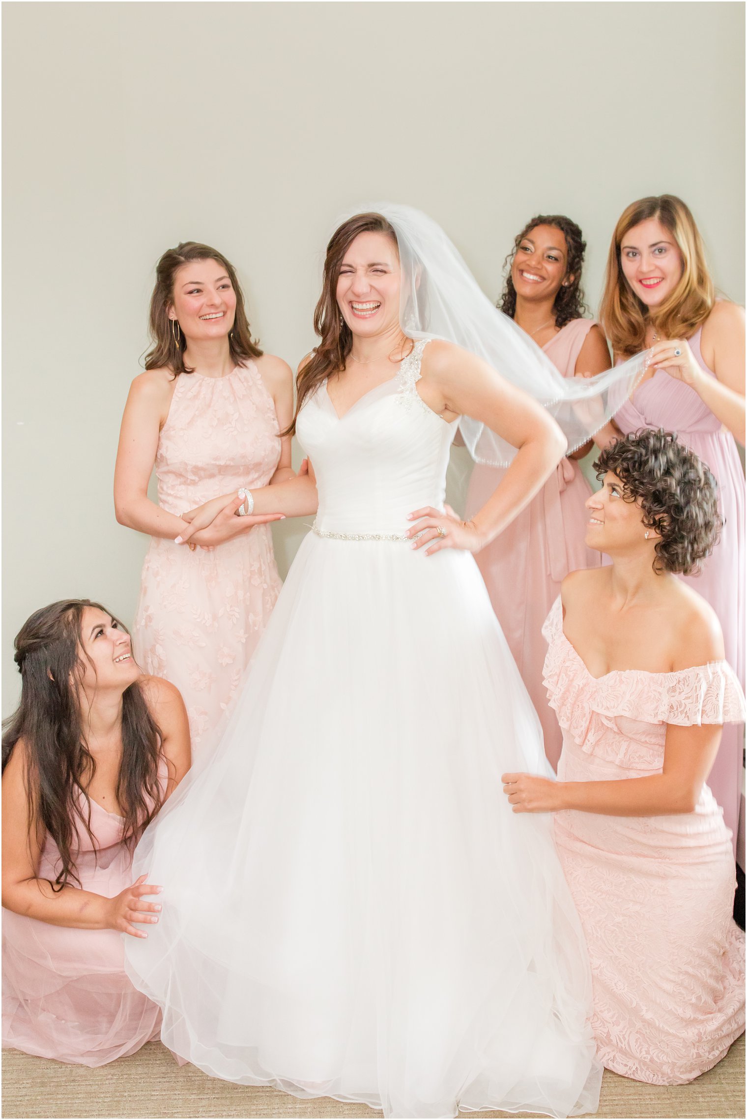 bridesmaids in pink help bride prep for NJ wedding