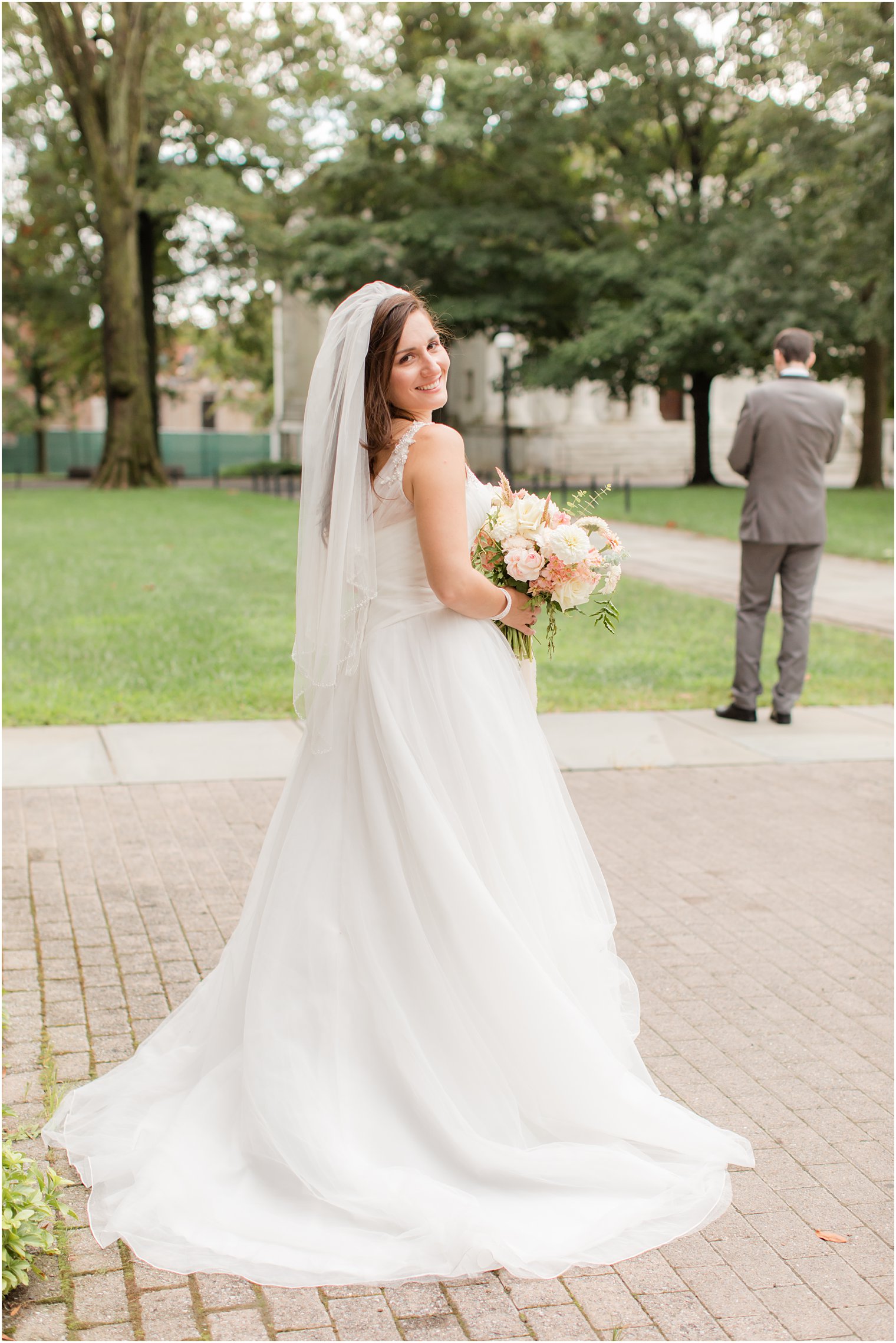 bride looks over shoulder before walking to groom for first look
