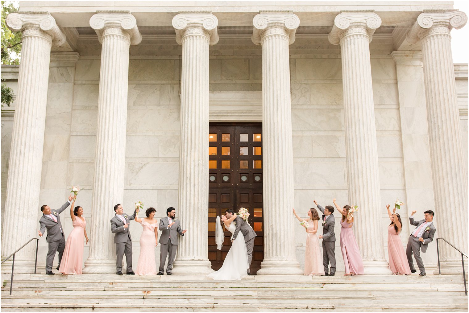 bride and groom kiss with wedding party cheering them on in Princeton NJ