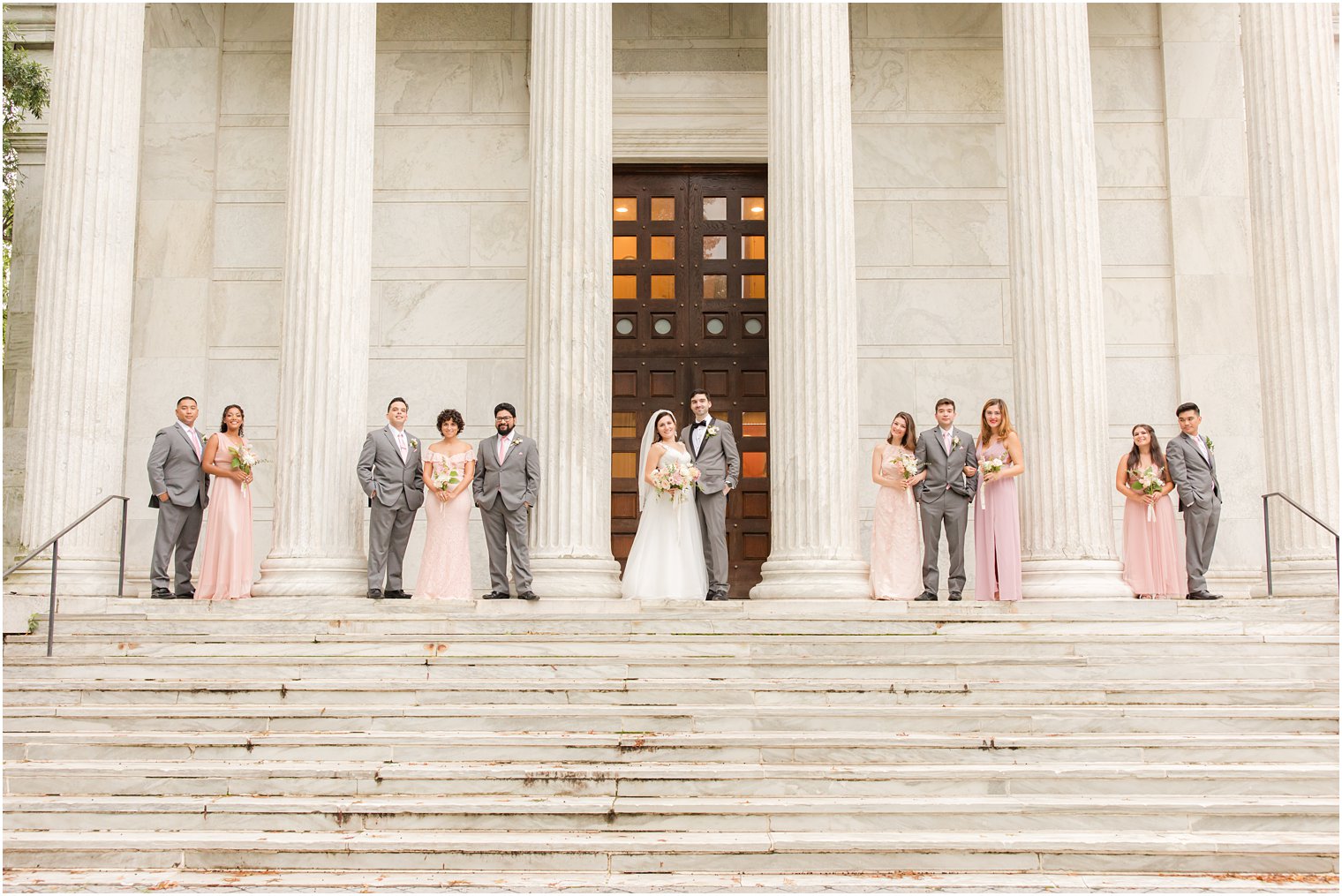bride and groom stand with wedding party on steps at Princeton University