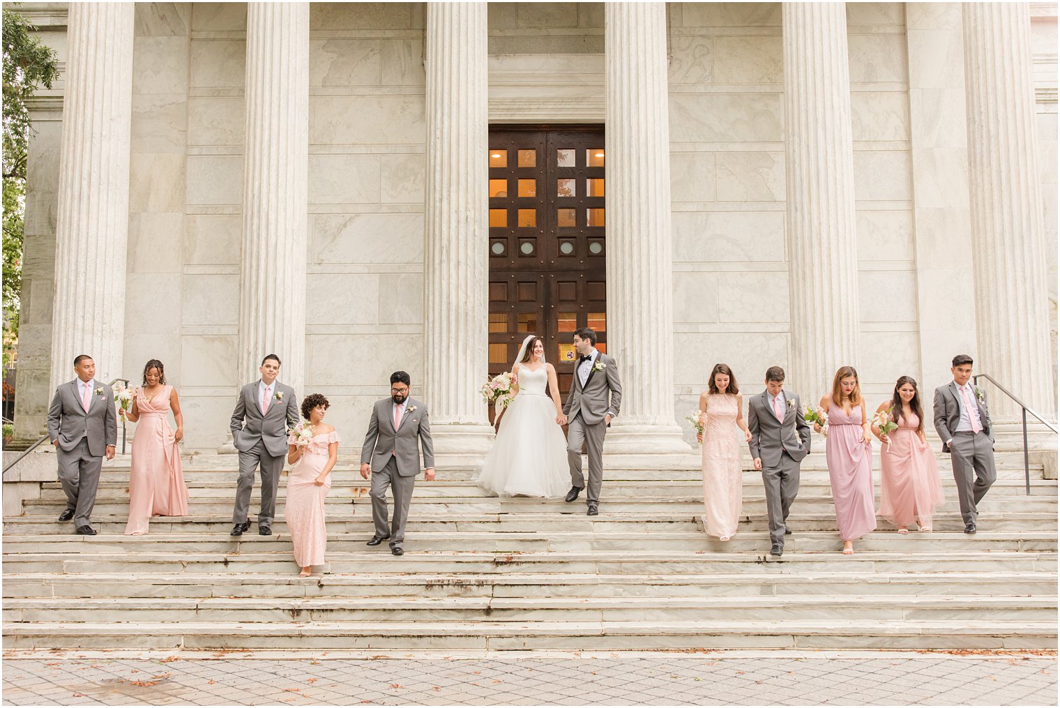 bride and groom walk down steps at Princeton University with wedding party