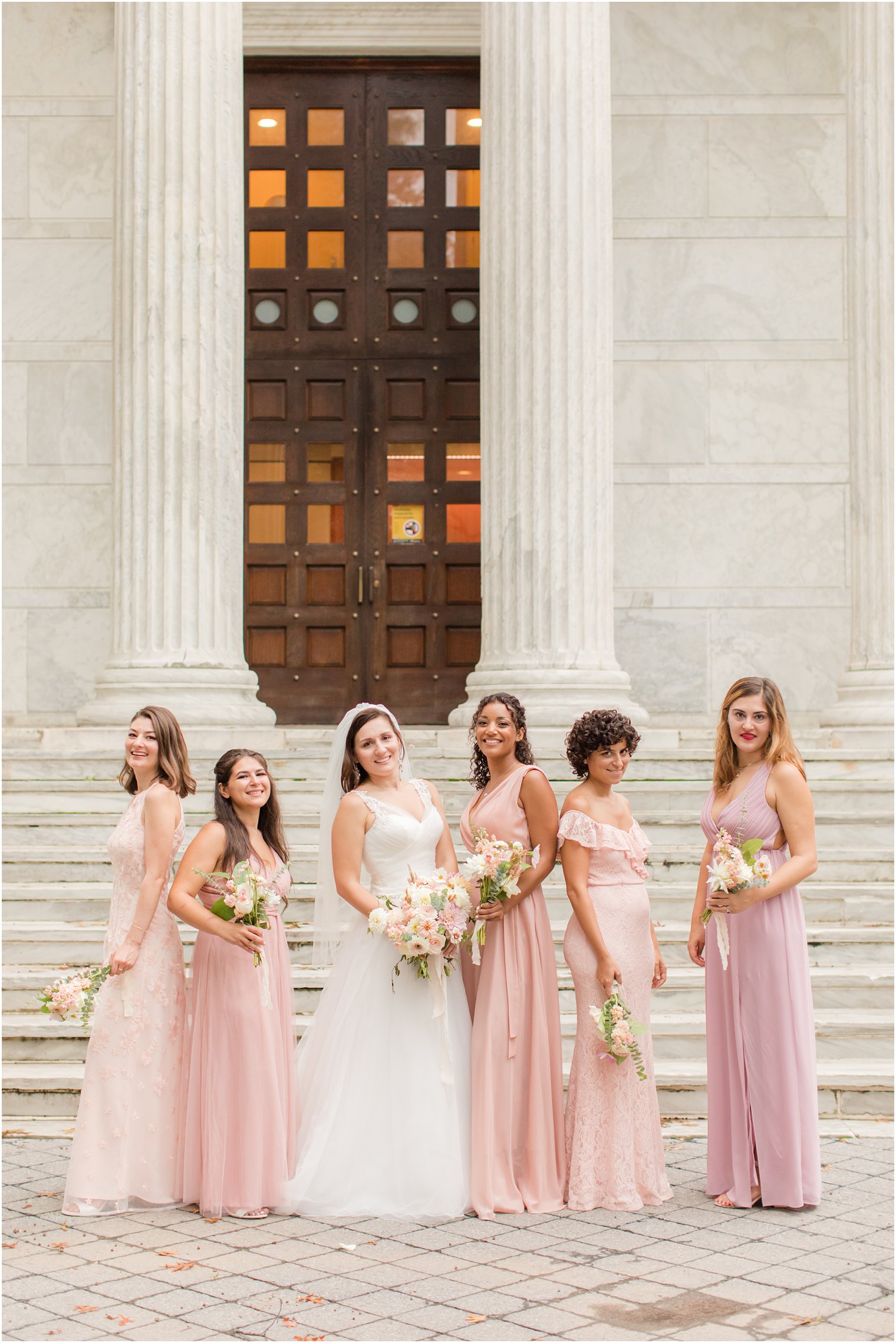 bride poes with five bridesmaids in pink dresses at Princeton University