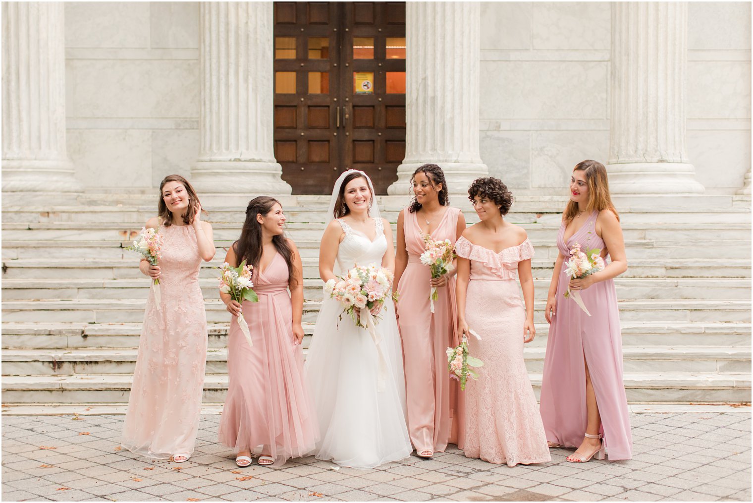 bride walks with bridesmaids in pink gowns at Princeton University