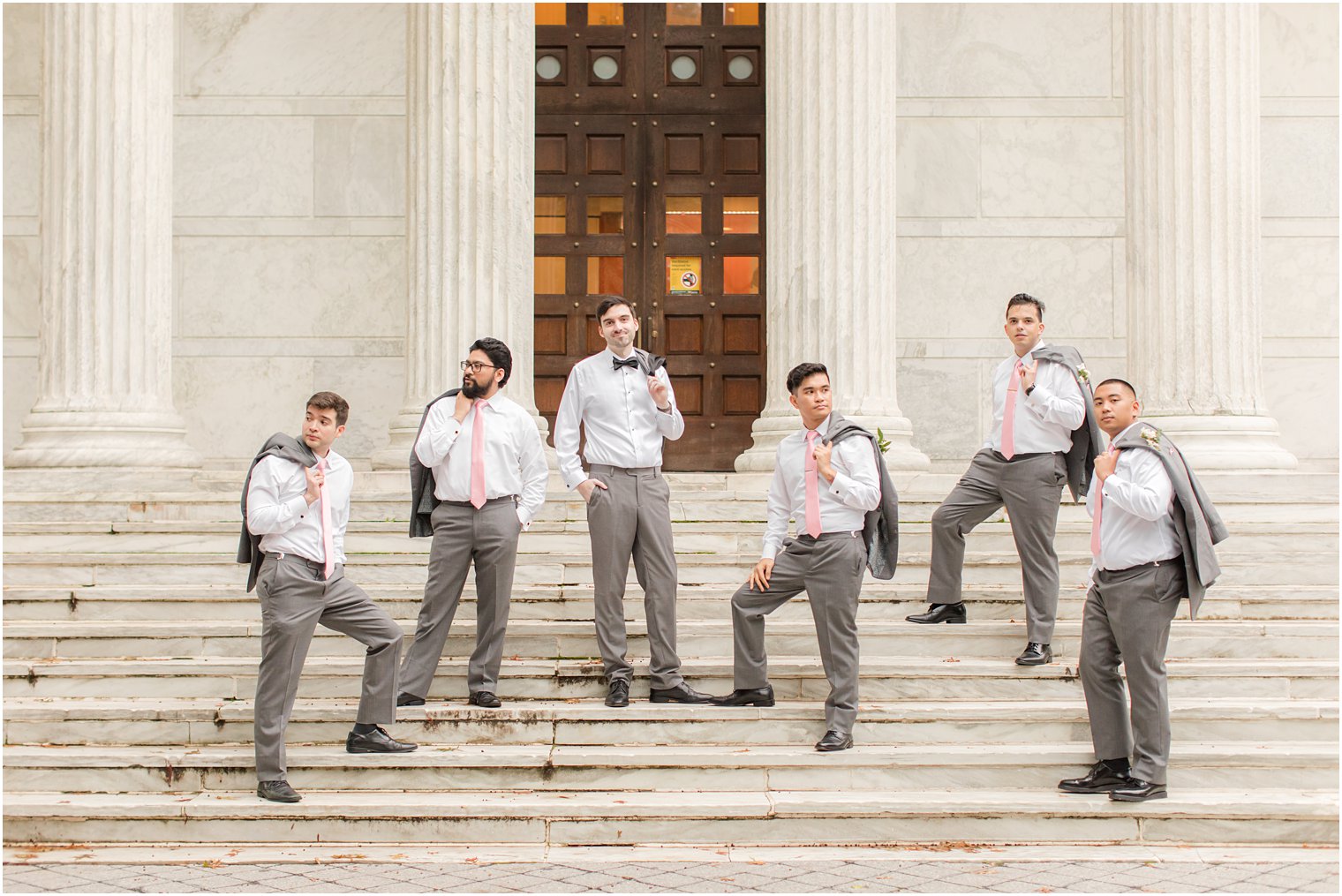 groom and groomsmen pose on steps of building at Princeton University