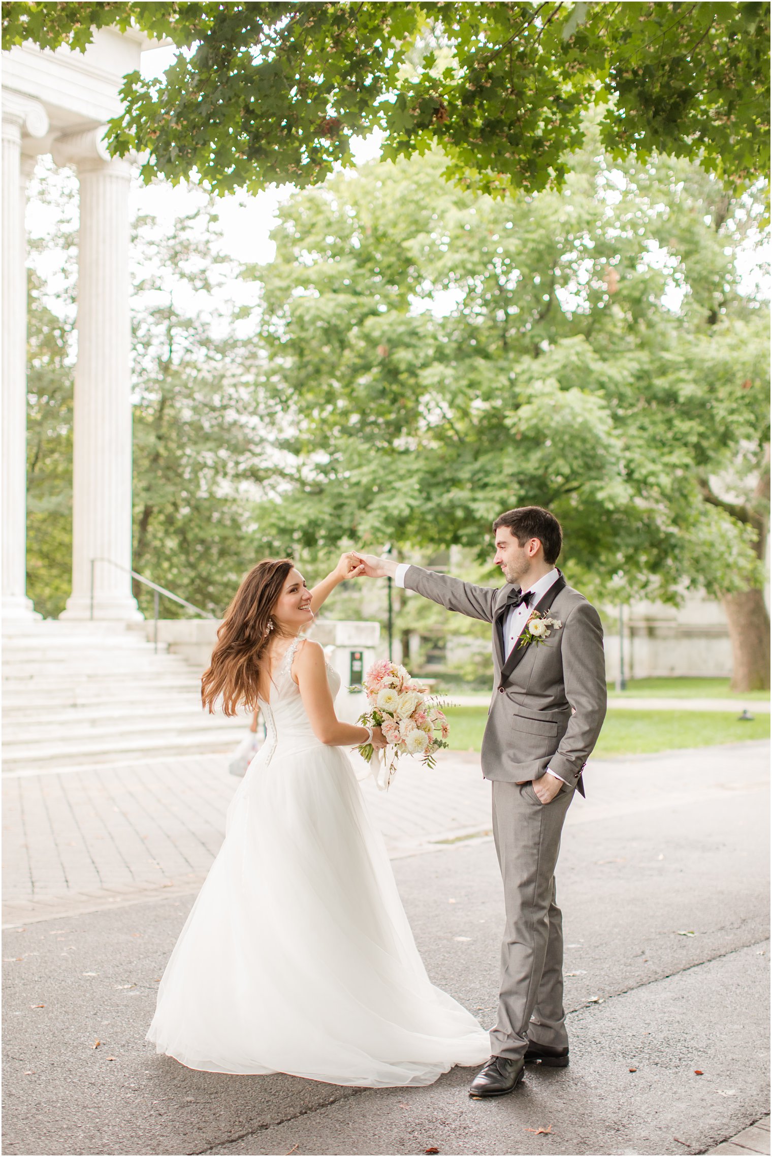 groom twirls bride along campus of Princeton University