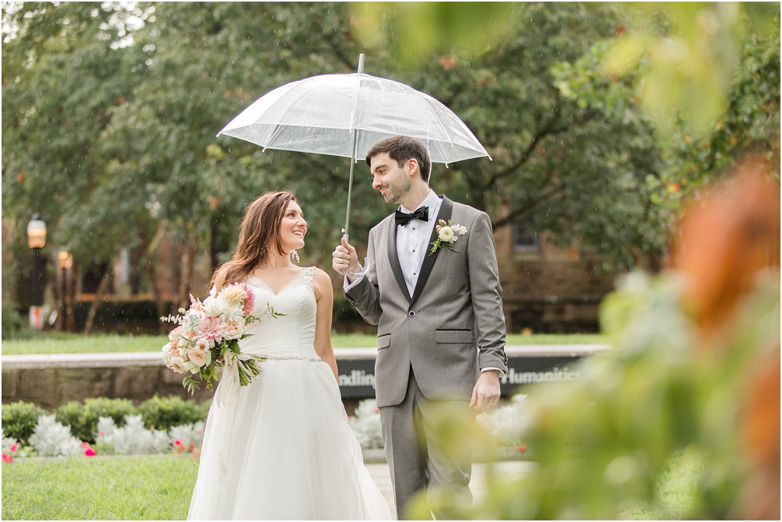 bride and groom walk under umbrella during NJ wedding photos