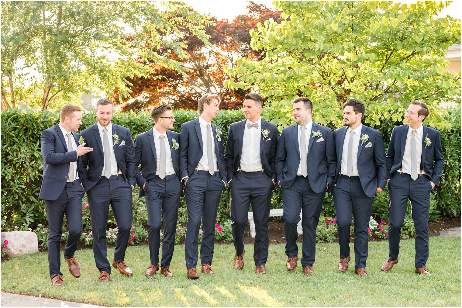 groom walks with groomsmen in navy suits at Crystal Point Yacht Club