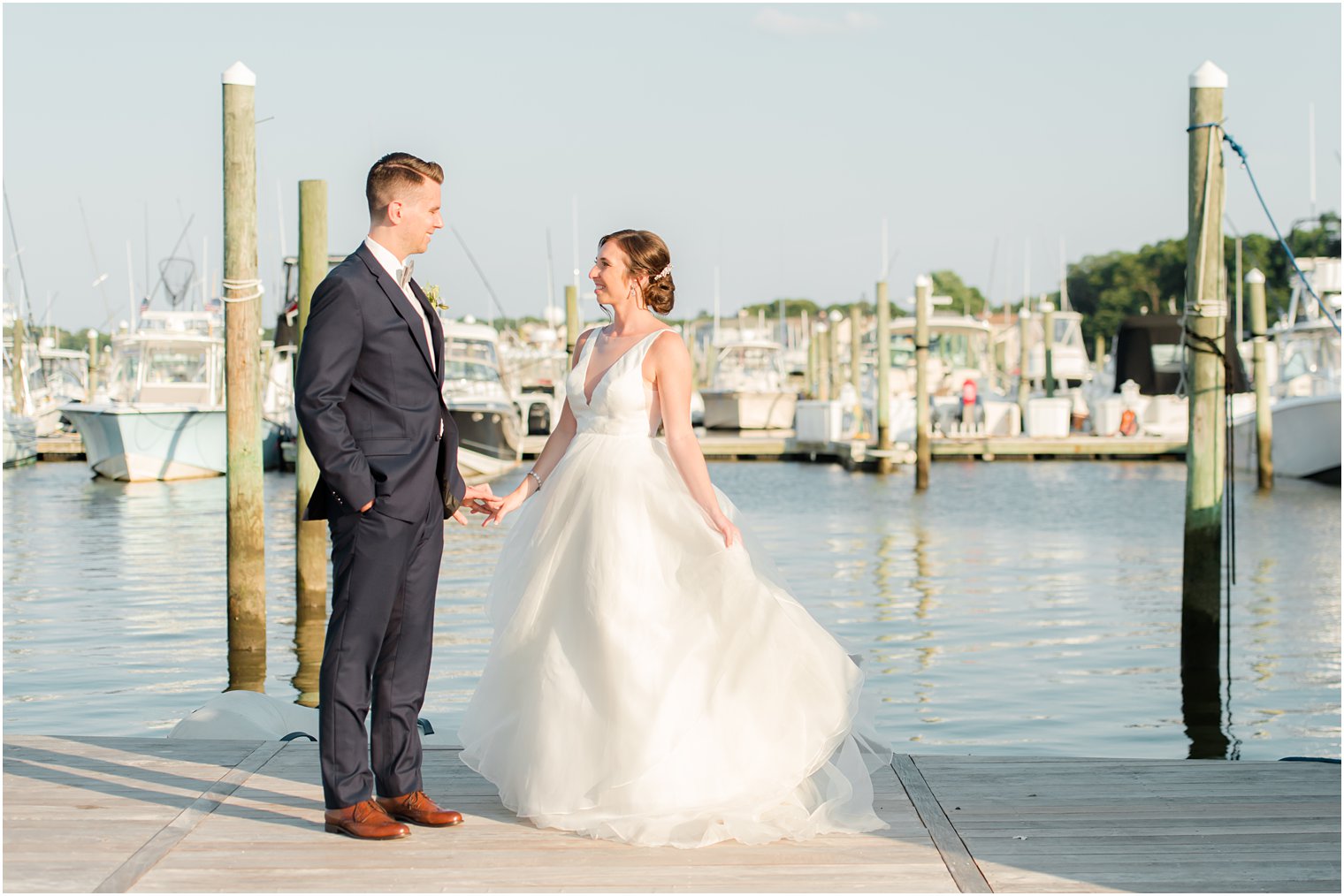 bride and groom pose on docks of Crystal Point Yacht Club