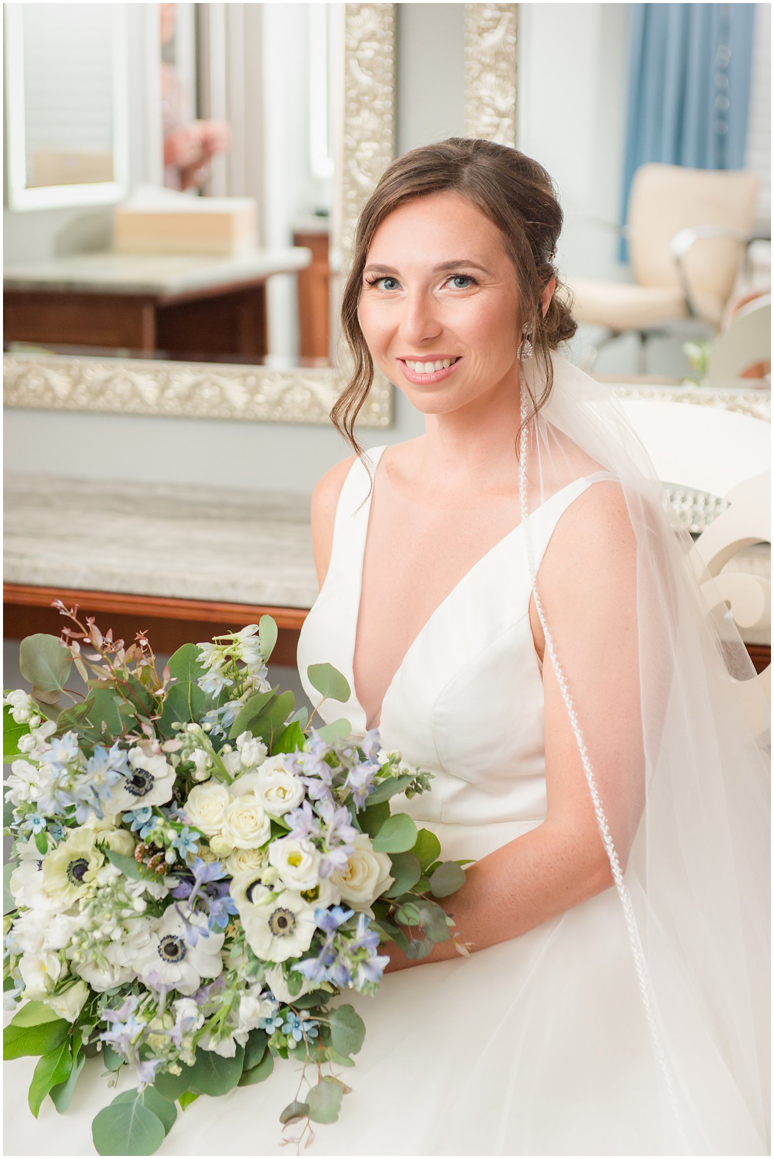 bride holds bouquet of white, ivory, and blue flowers for NJ wedding day