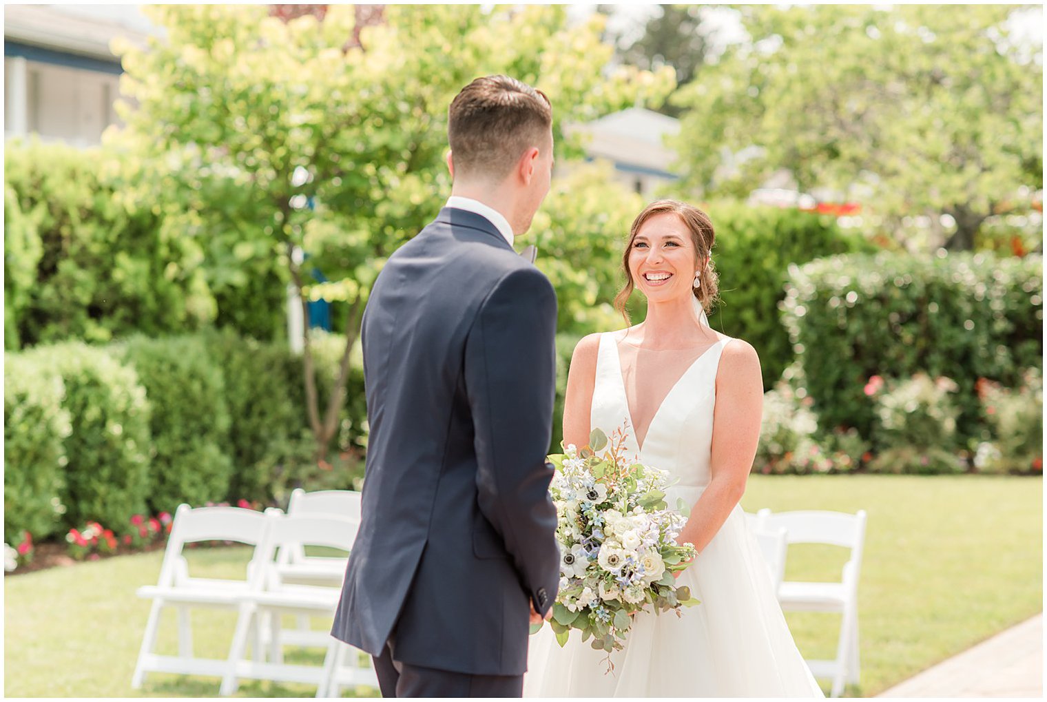bride laughs with groom during first look at Crystal Point Yacht Club