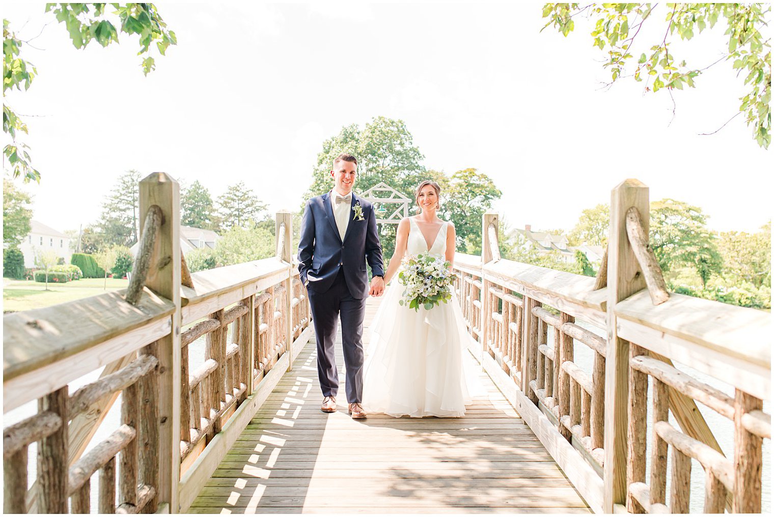 bride and groom hold hands walking on wooden bridge in Point Pleasant NJ