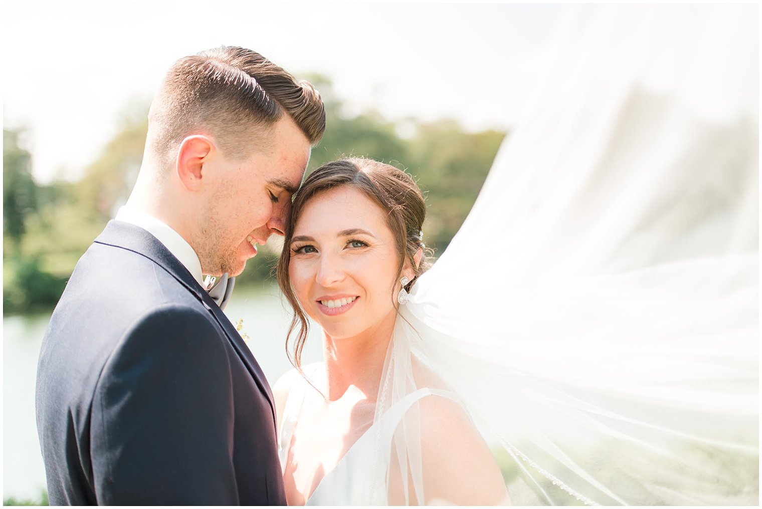 groom nuzzles bride's cheek with veil floating behind them