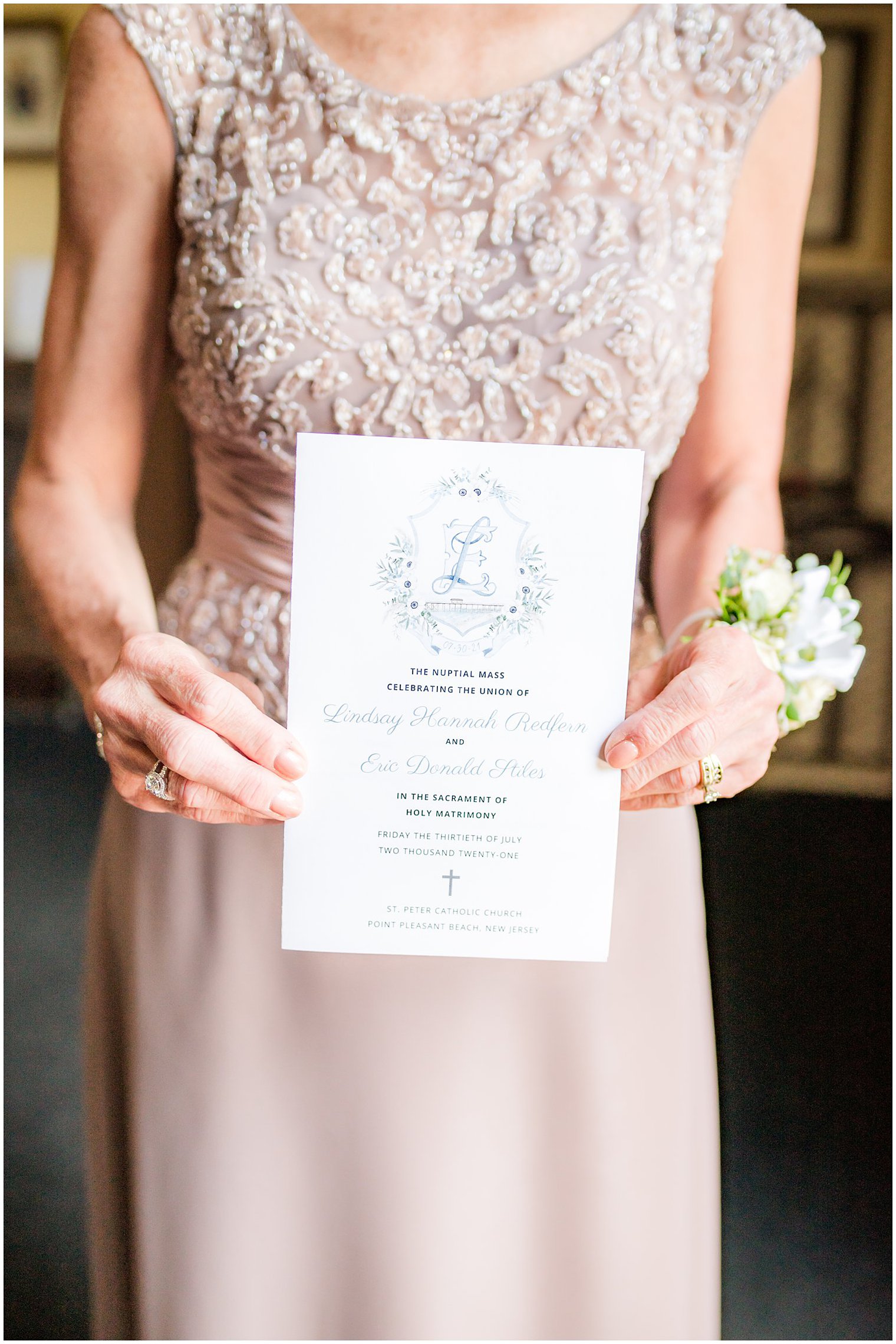mother of the bride holds wedding invitation before ceremony