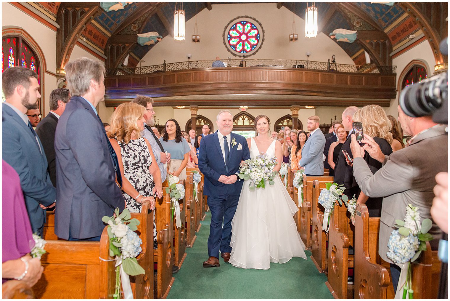 bride walks down aisle with father during traditional church wedding in NJ