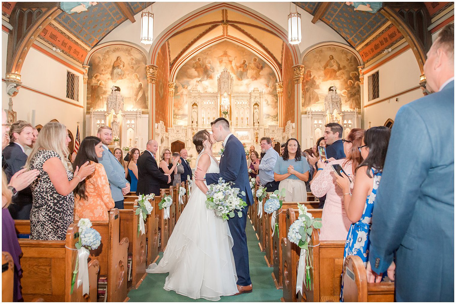 bride and groom kiss in aisle during traditional church wedding in NJ
