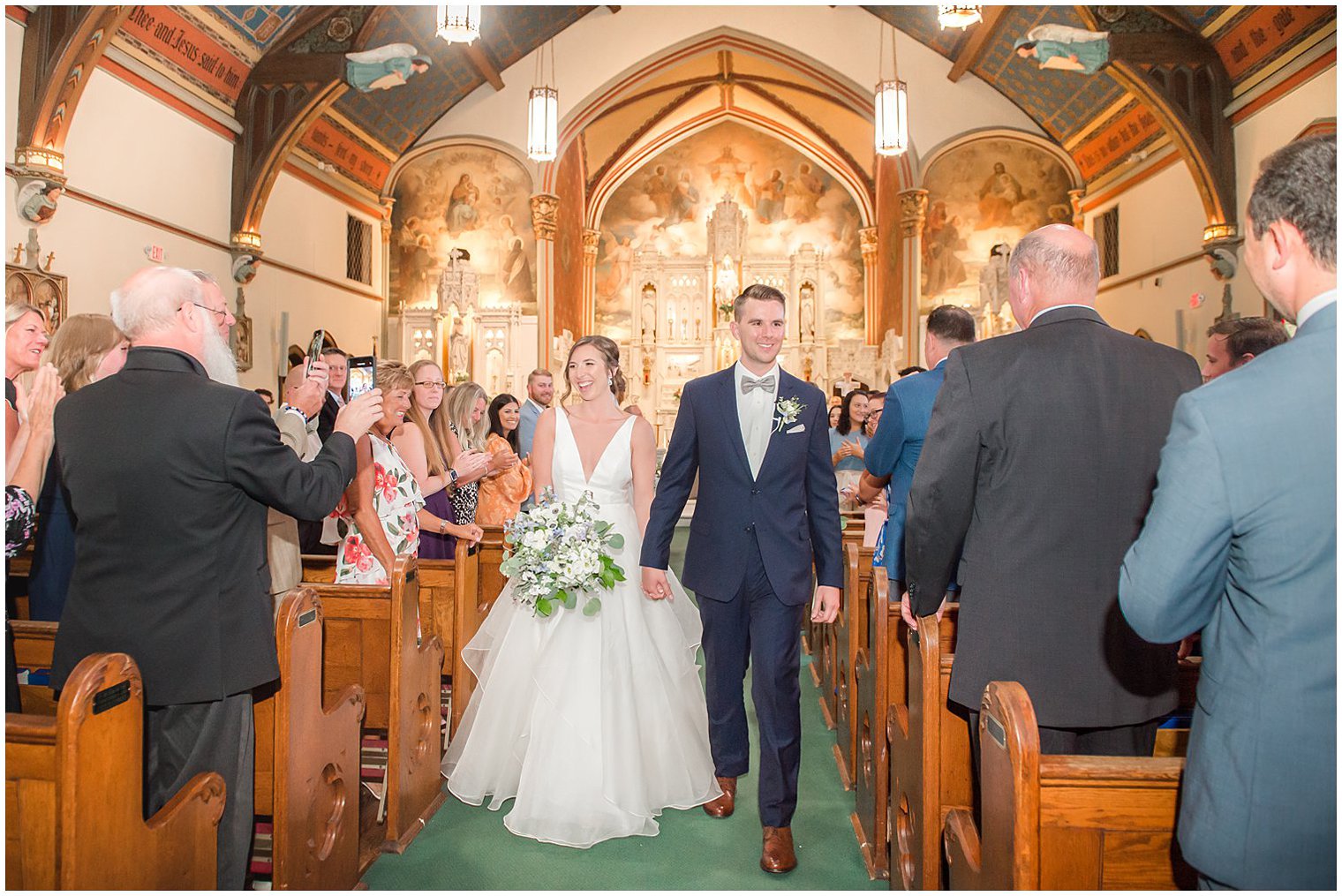 newlyweds walk up aisle during traditional church wedding in NJ