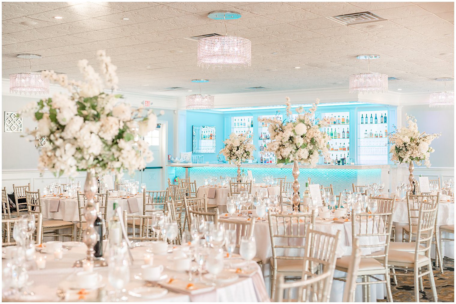 tables with tall white floral centerpieces at reception in Point Pleasant NJ