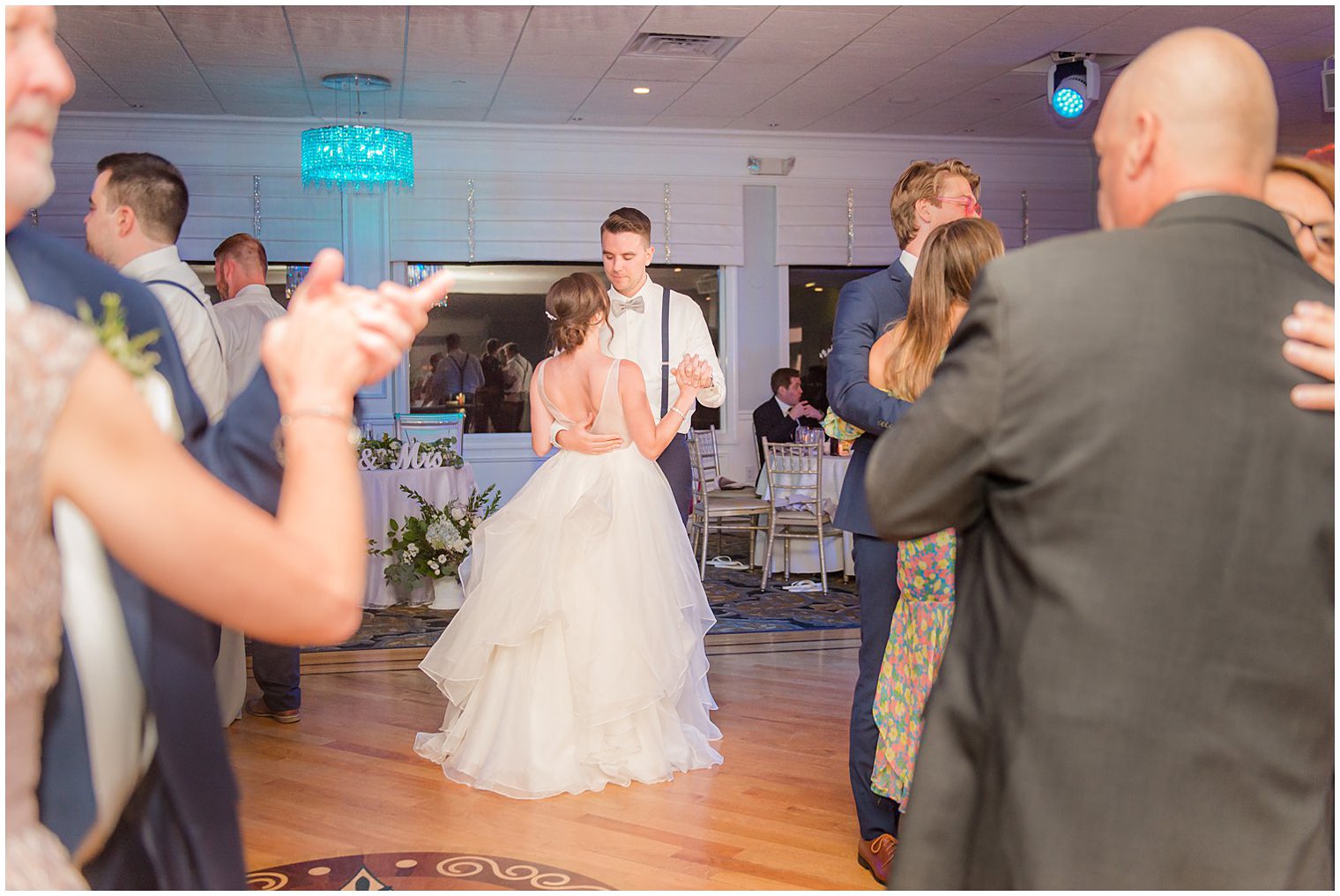 bride and groom dance during NJ wedding reception with guests