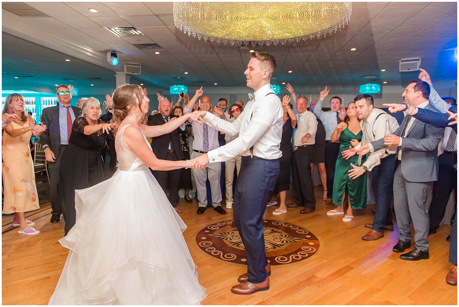 bride and groom dance in circle of wedding guests during NJ wedding reception