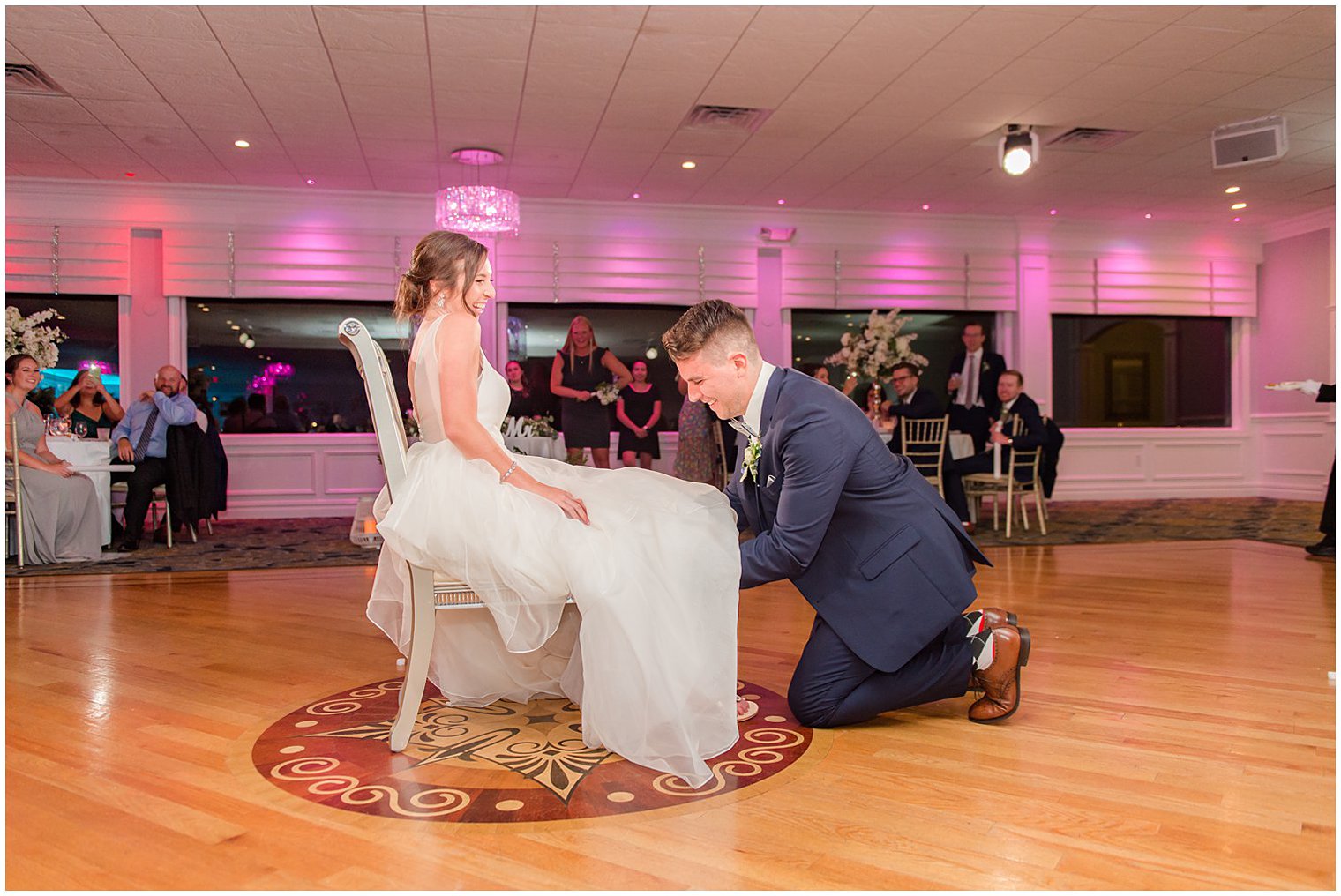 groom gets garter from bride's leg during NJ wedding reception