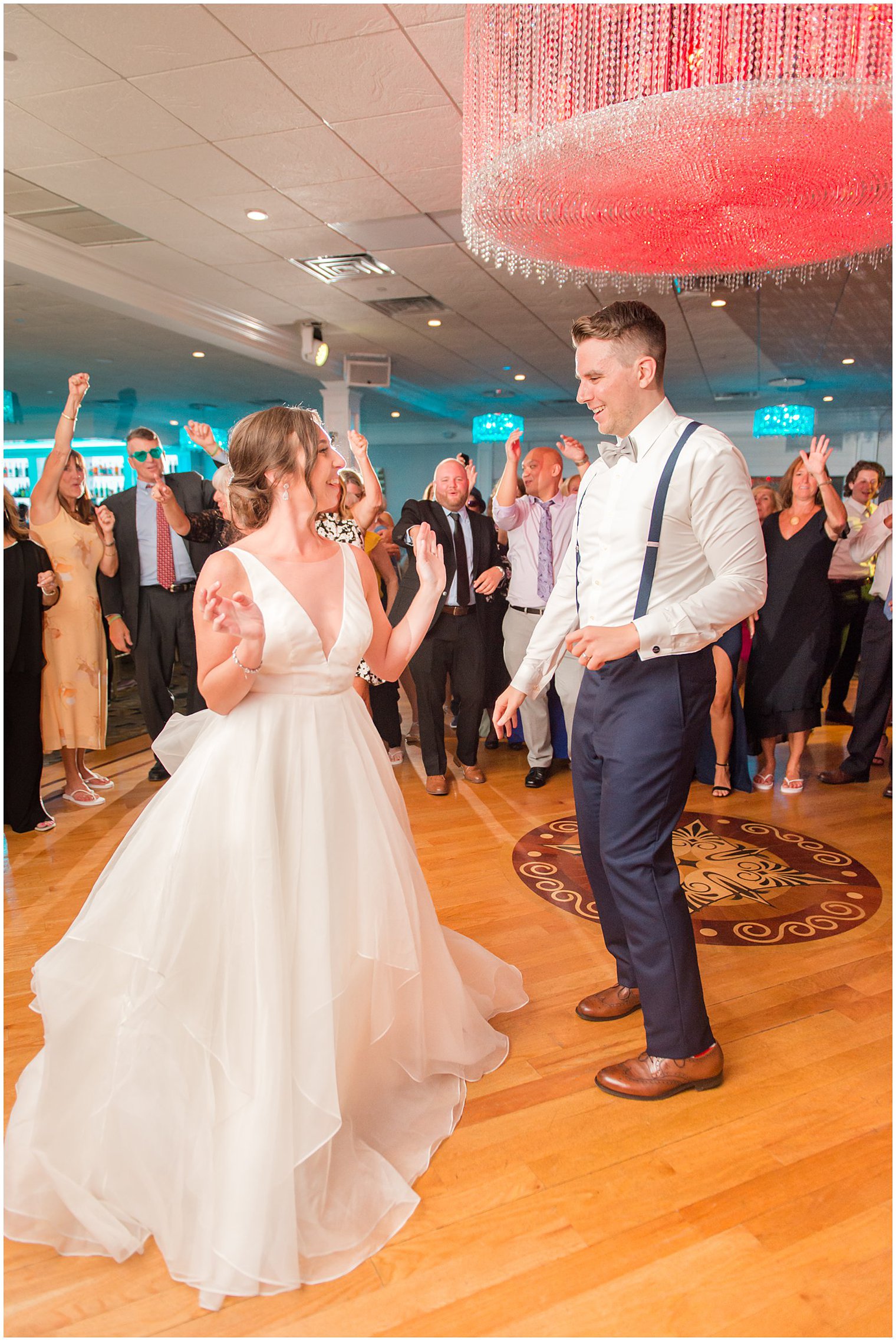 bride and groom dance in circle of guests