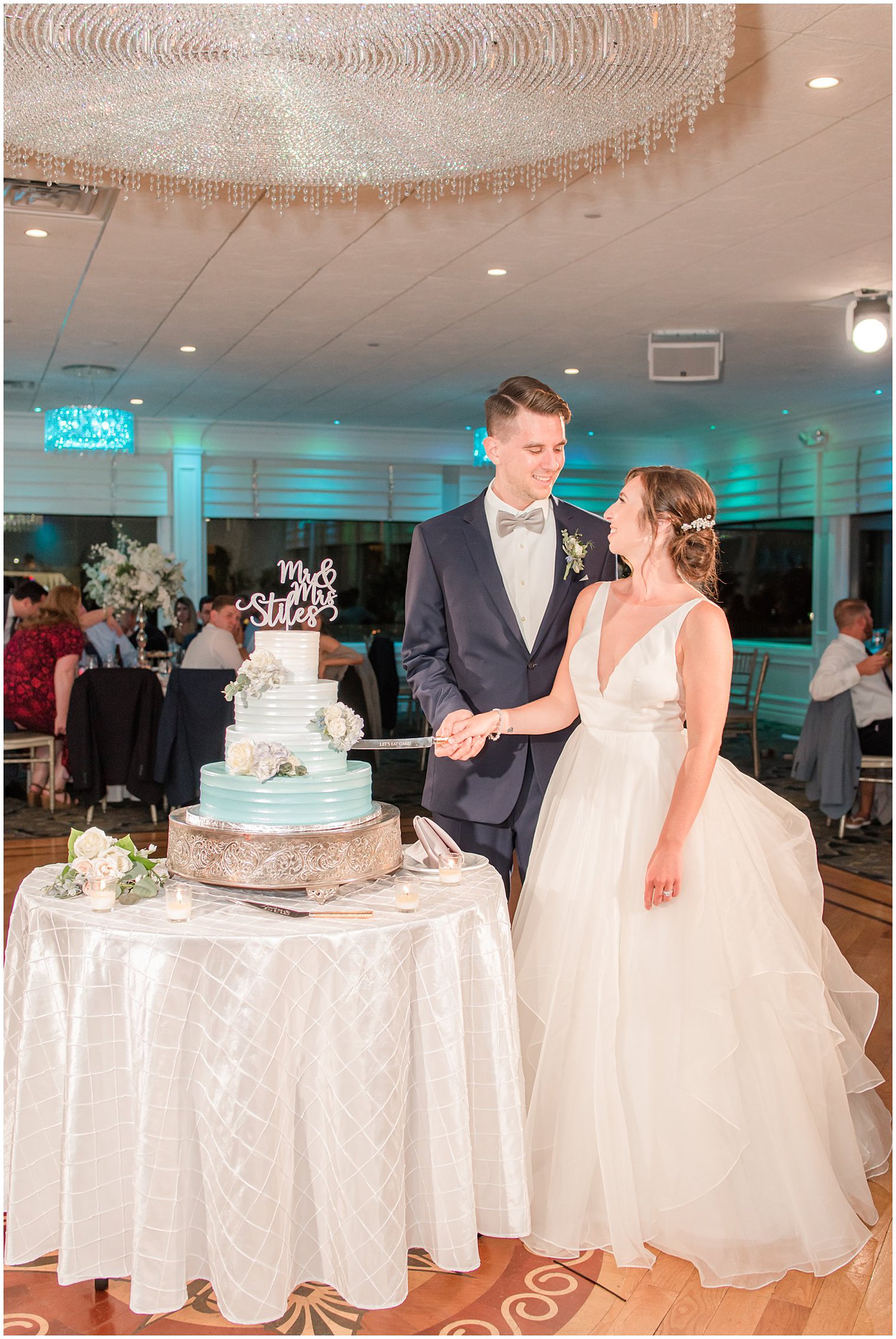 bride and groom cut wedding cake at Crystal Point Yacht Club