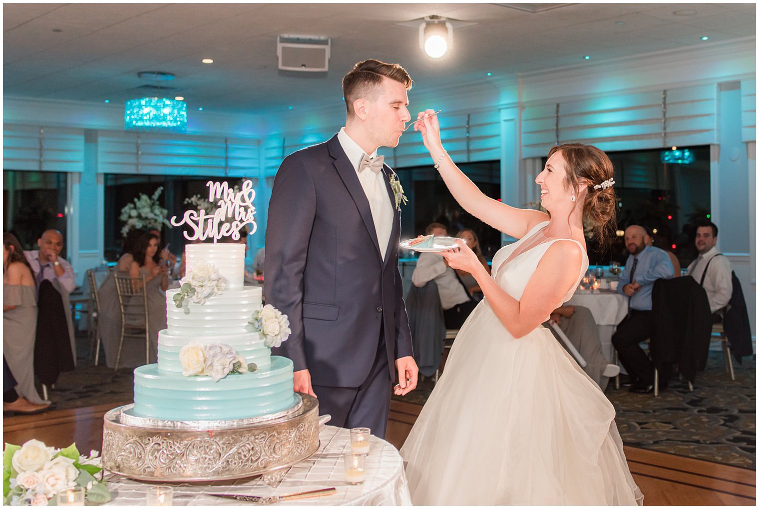 bride feeds groom cake during wedding reception