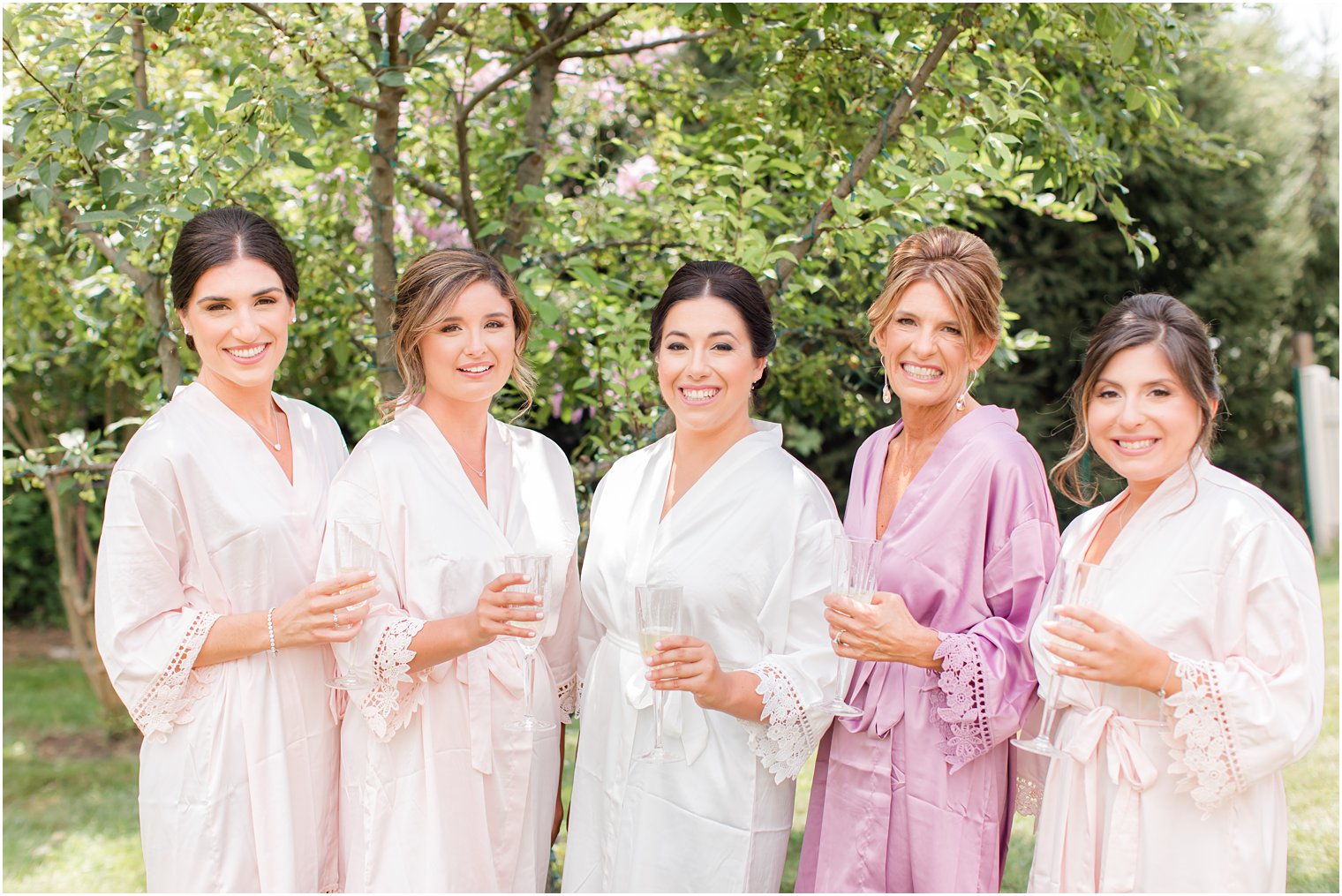bride and bridesmaids toast champagne during NJ wedding